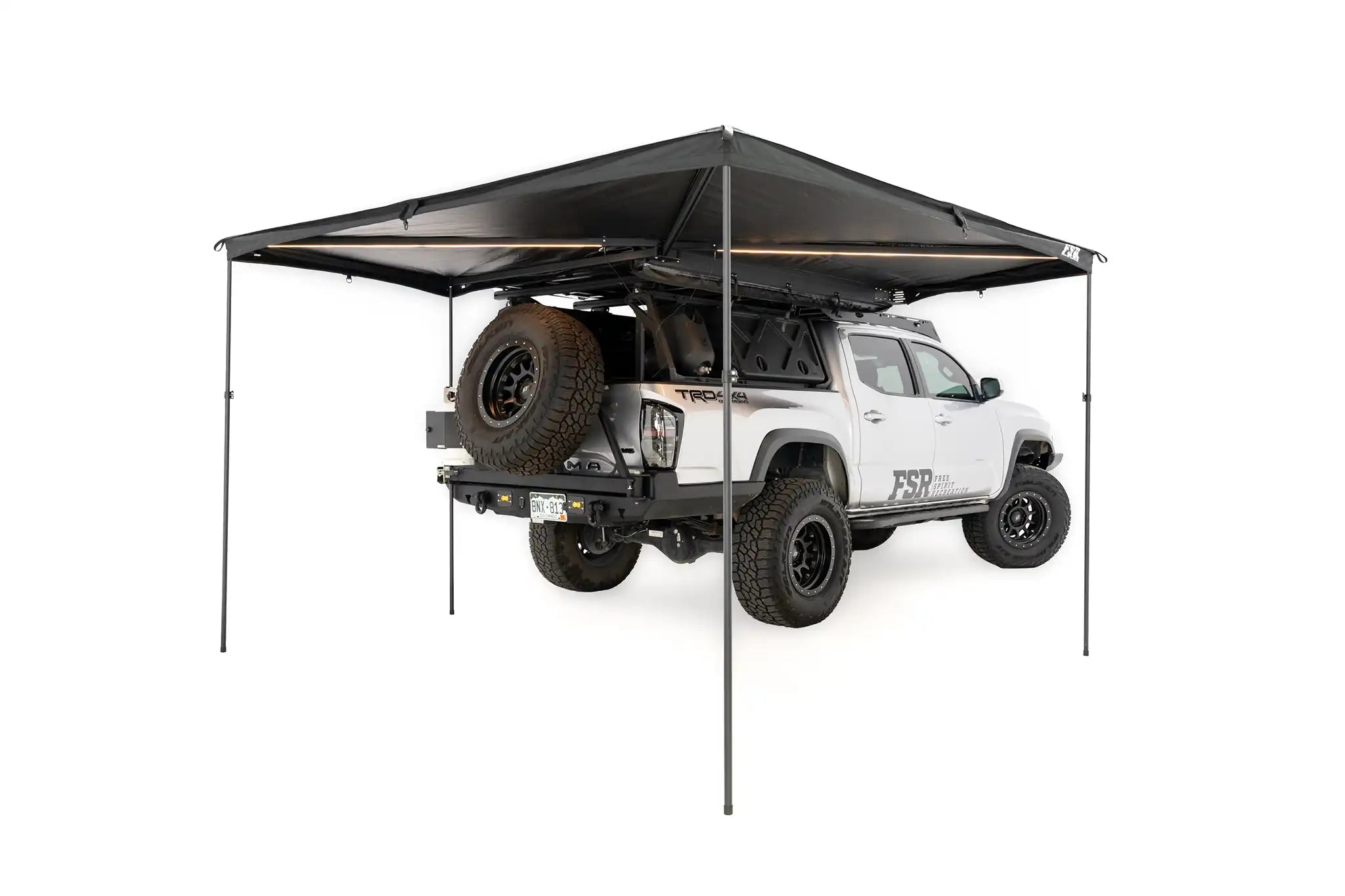 Freespirit Recreation 270 Awning V2 with optional support poles, shown extended with fabric and frame in outdoor setting