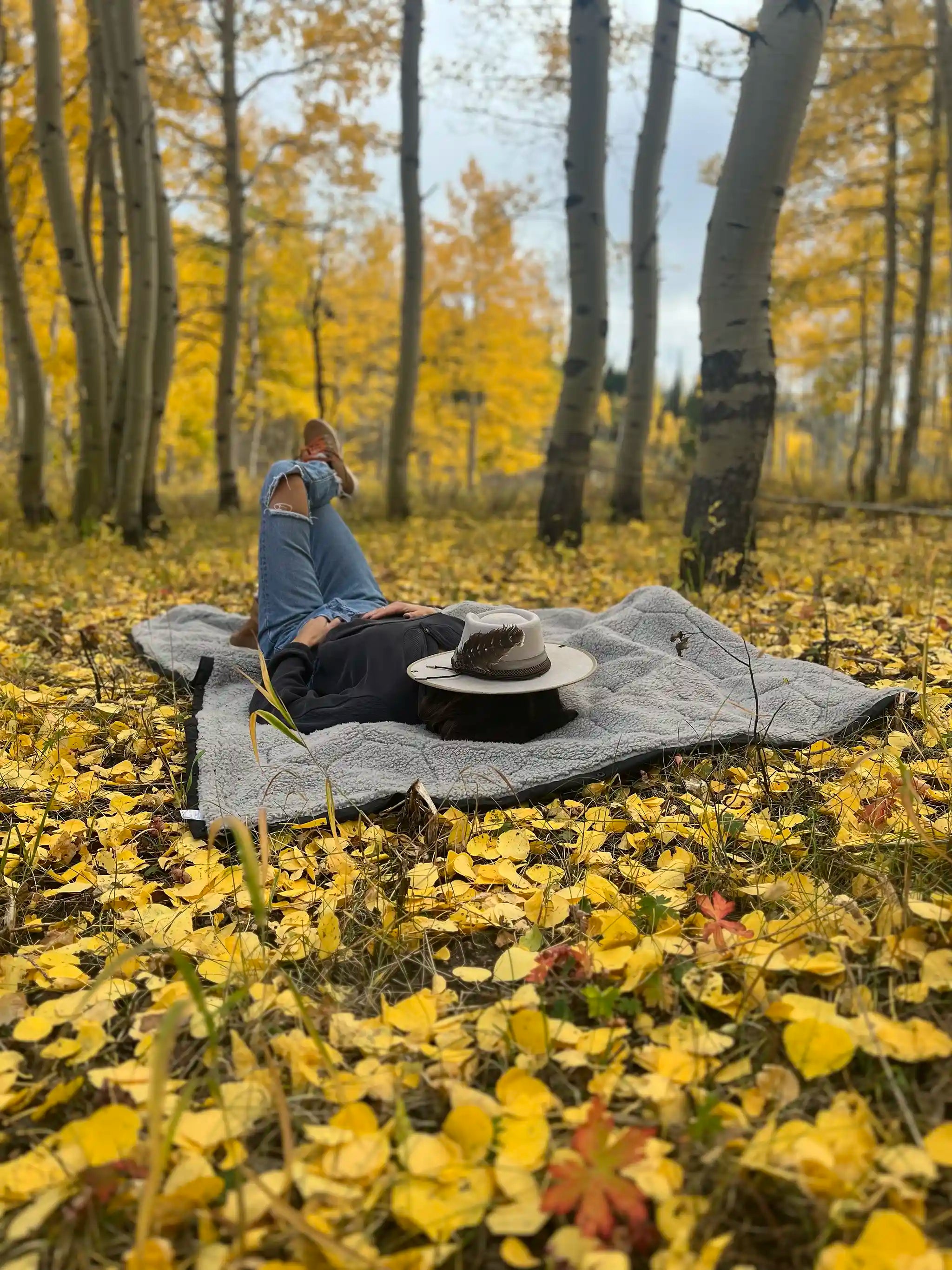 Freespirit Recreation Anywhere Poncho camping blanket worn as outerwear, in outdoor setting, showcasing its cozy, versatile design.