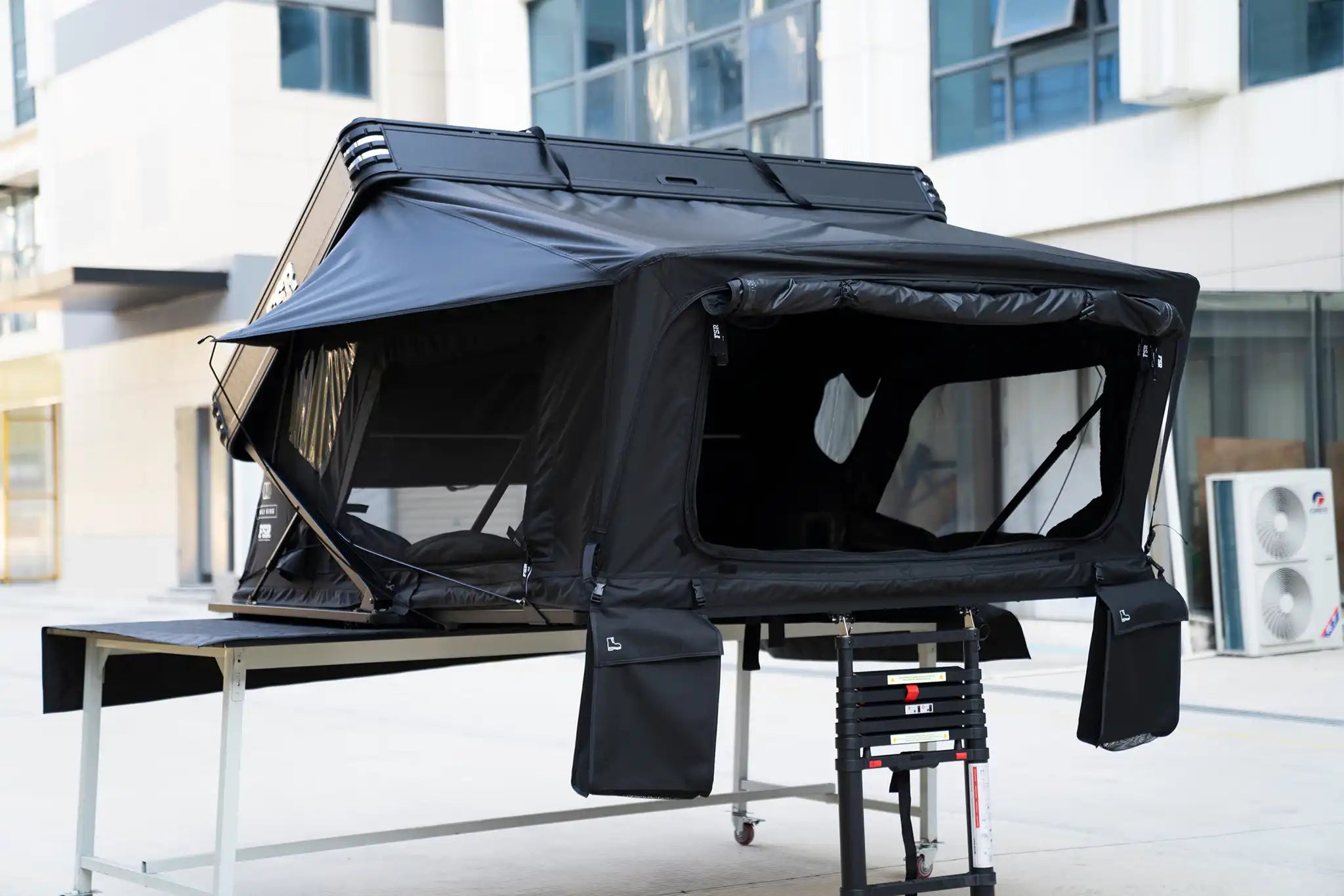 Freespirit Recreation Kali King rooftop tent mounted on a vehicle, showing its front and side views with window details.