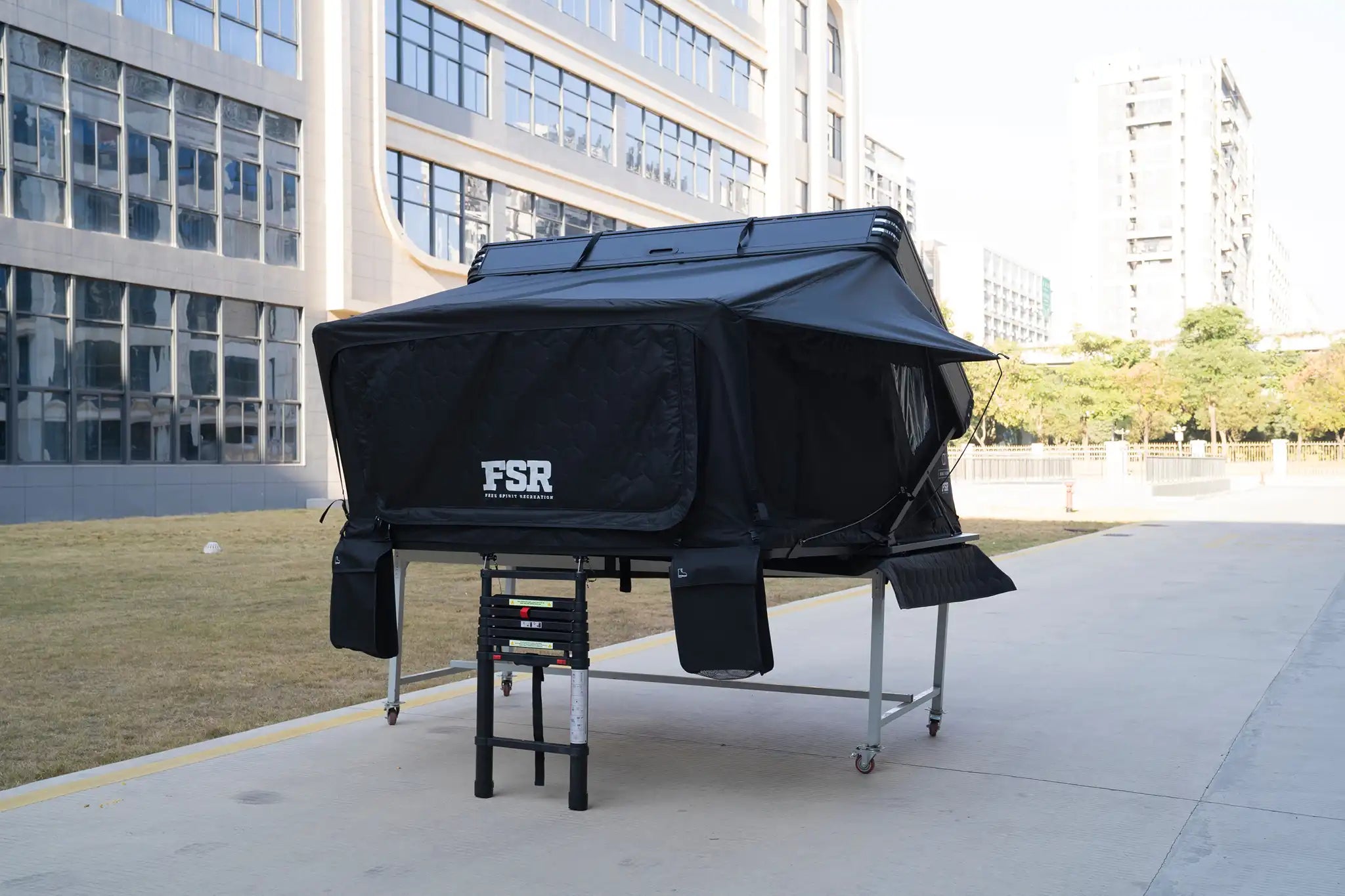 Freespirit Recreation Kali King rooftop tent with shoe storage and skirt, set up outdoors on a vehicle for camping.