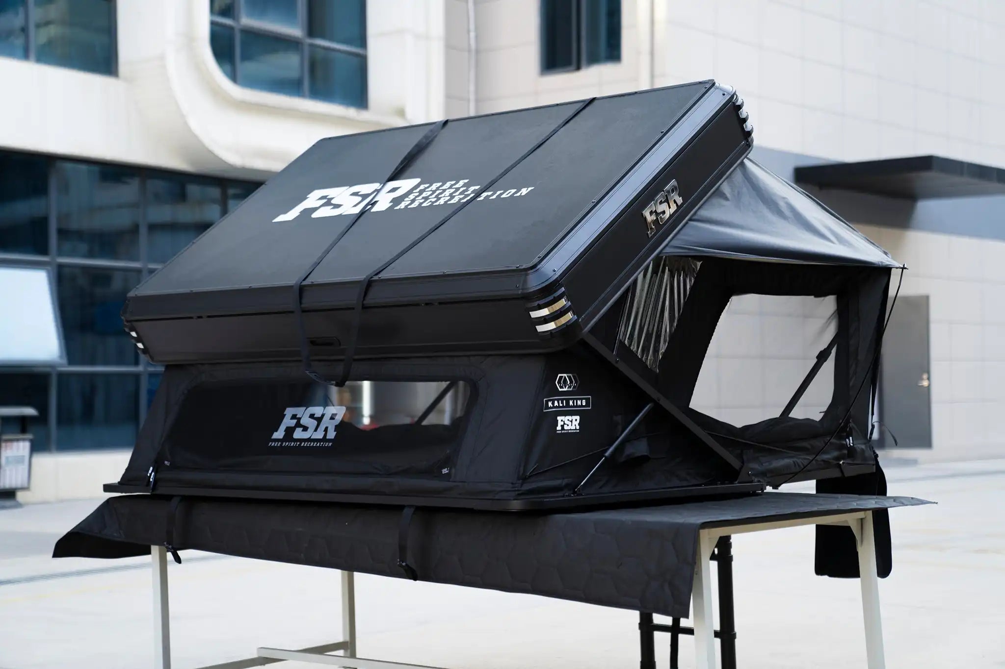 Freespirit Recreation Kali King rooftop tent shown from side and back, featuring durable fabric, extended awning, and sturdy frame.