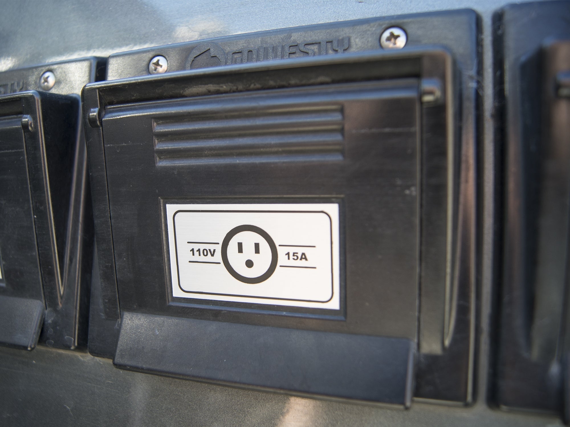 GoWesty 110 Volt Electrical Hook-Up Box for camper vans, showing the outdoor electrical connection with cable and weatherproof housing.