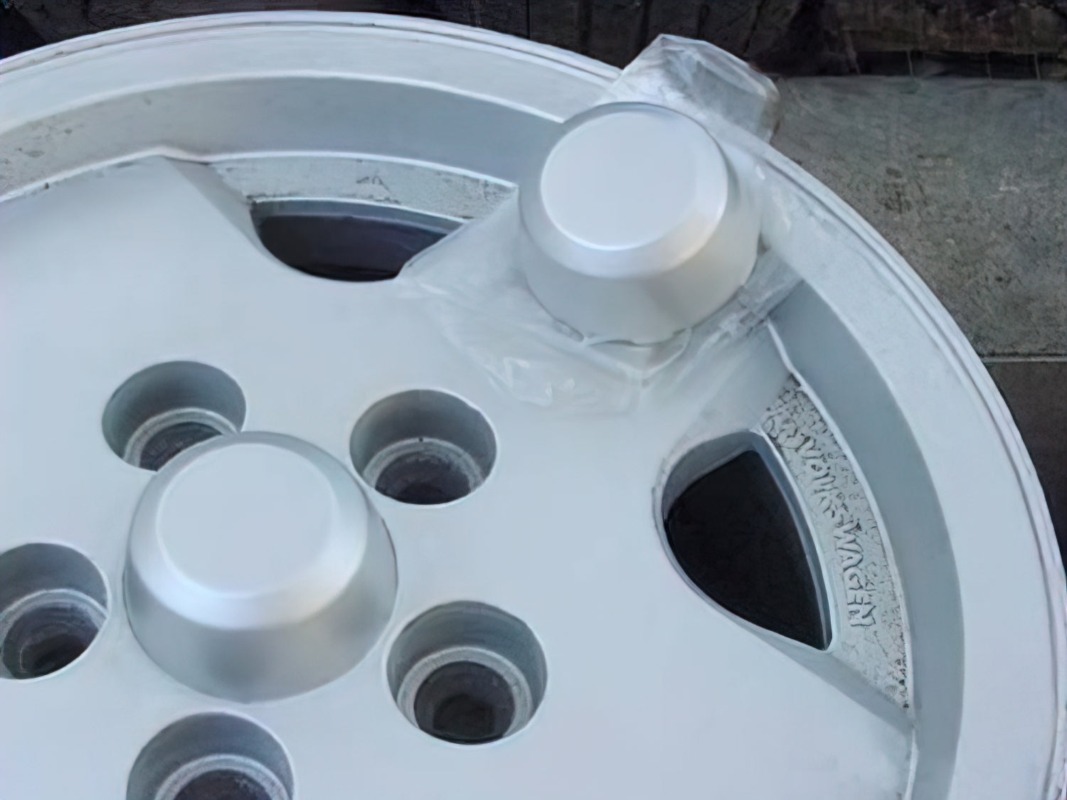 GoWesty center hubcap for factory alloy wheels, showcasing a sleek, circular design with a polished metal finish.