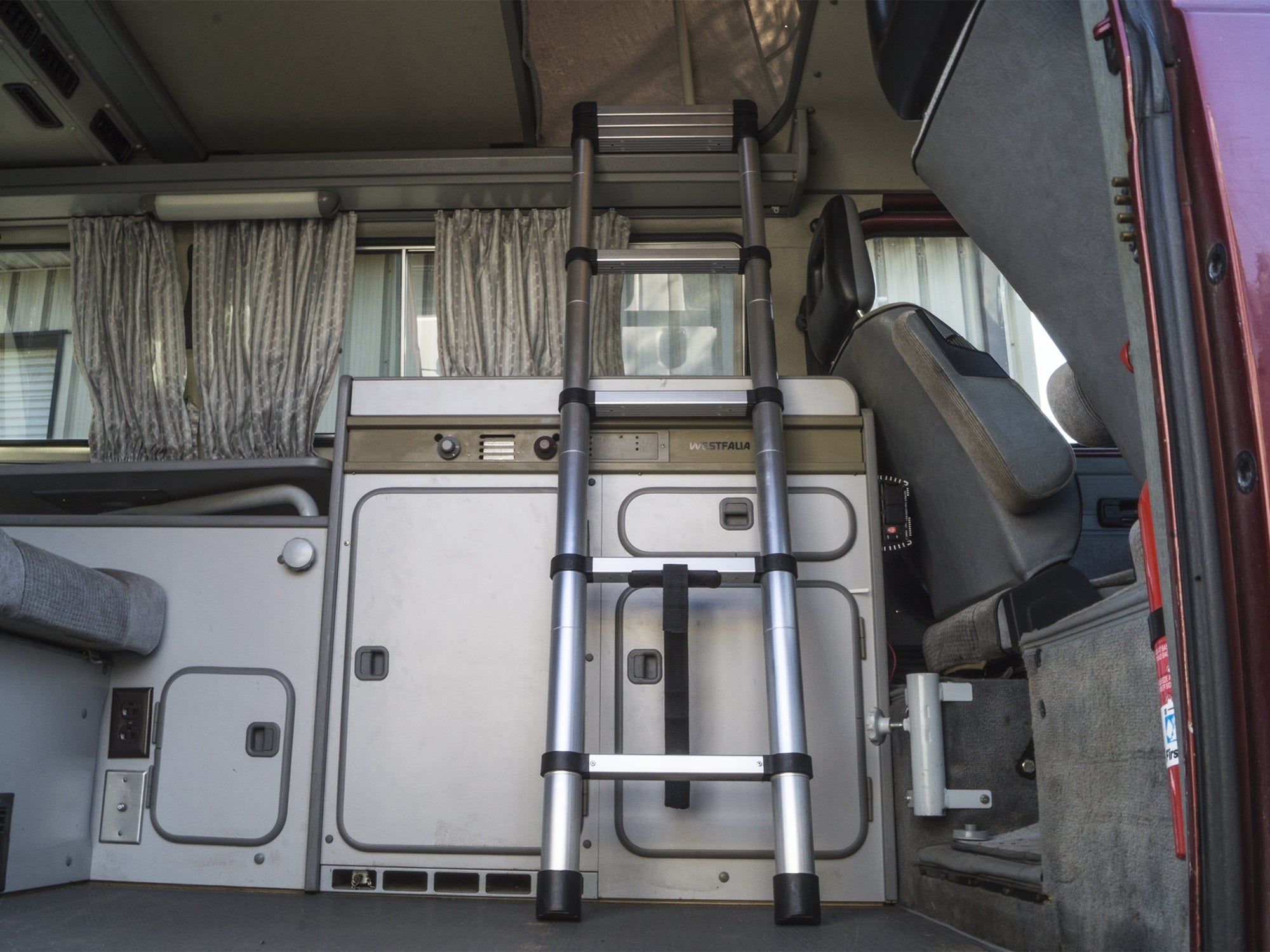 GoWesty telescoping ladder extended for exterior use, showing its lightweight aluminum design and multiple rungs for versatile access.