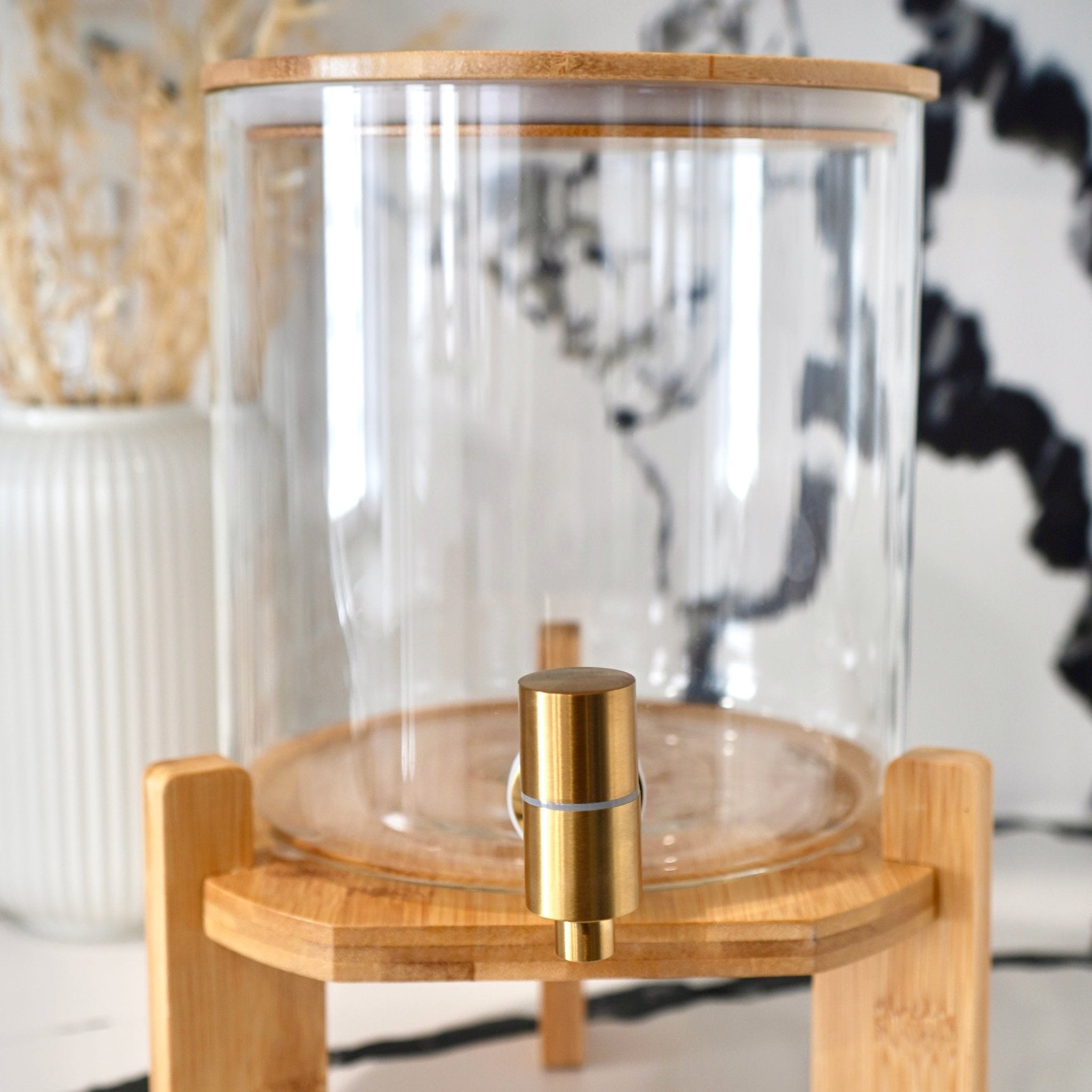 Glass drink dispenser with stand from Tea + Linen, clear glass container for beverages, ideal for parties or gatherings.