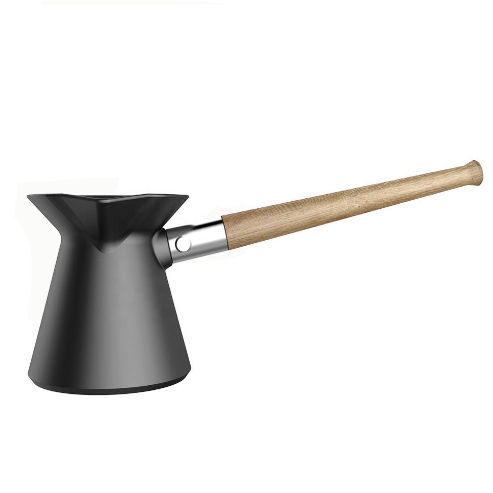 Hakan Coffee Pot by Tea + Linen shown with a sleek, modern design and polished metallic finish on a wooden table.