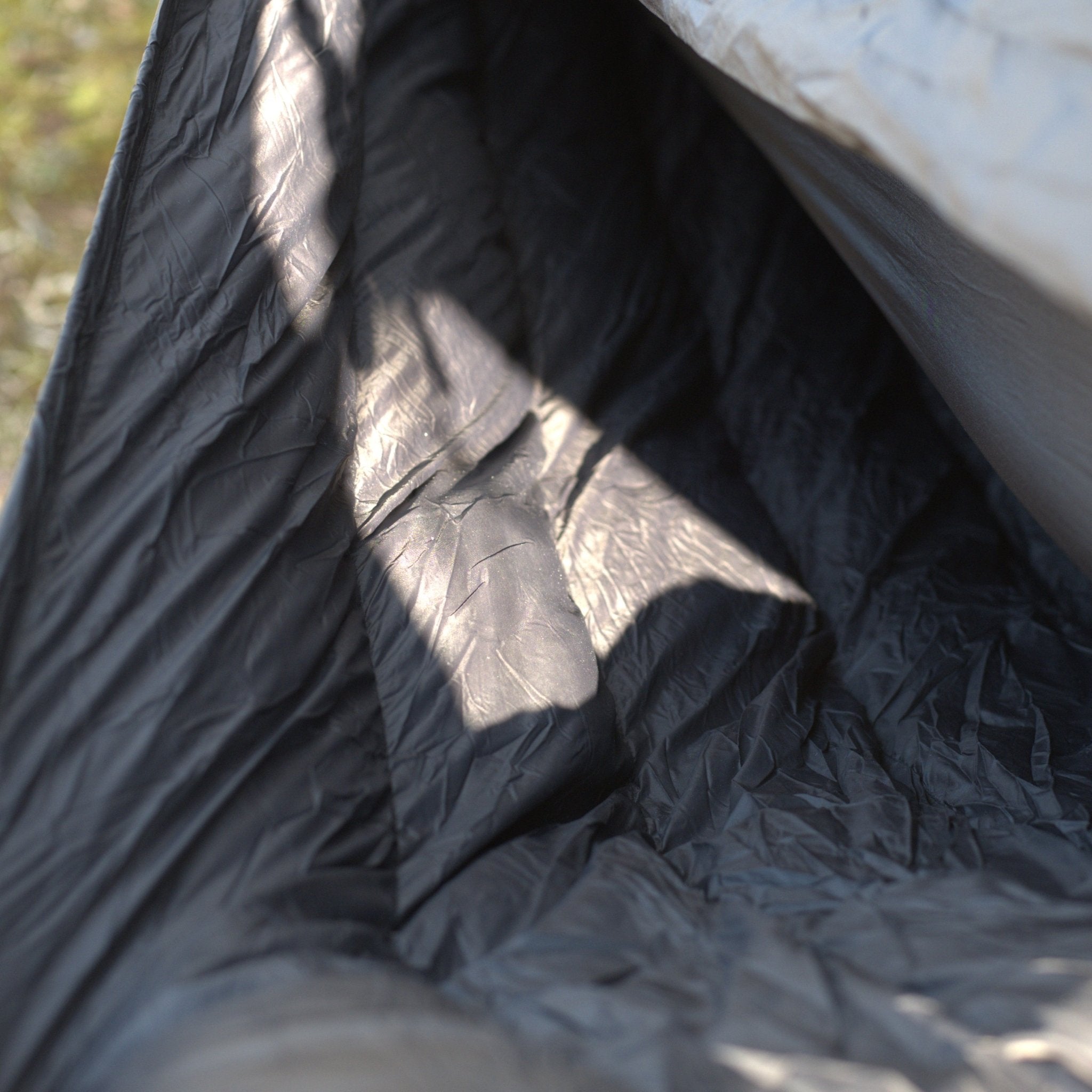 Hanging High Hammocks EmberNest Underquilt, 30°F rated, in navy, displayed on a hammock for cold weather camping insulation.