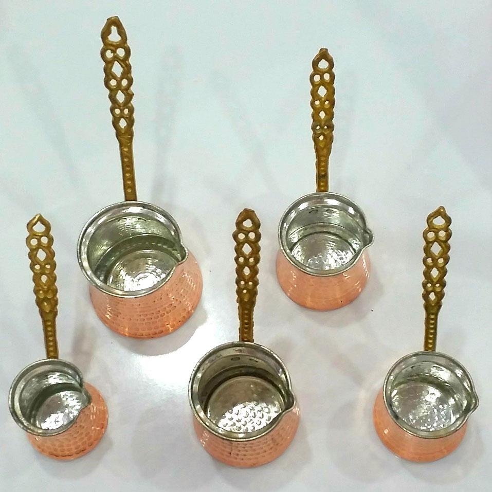 Handmade Copper Ibrik from Tea + Linen with a traditional curved spout and wooden handle, used for brewing Turkish coffee.