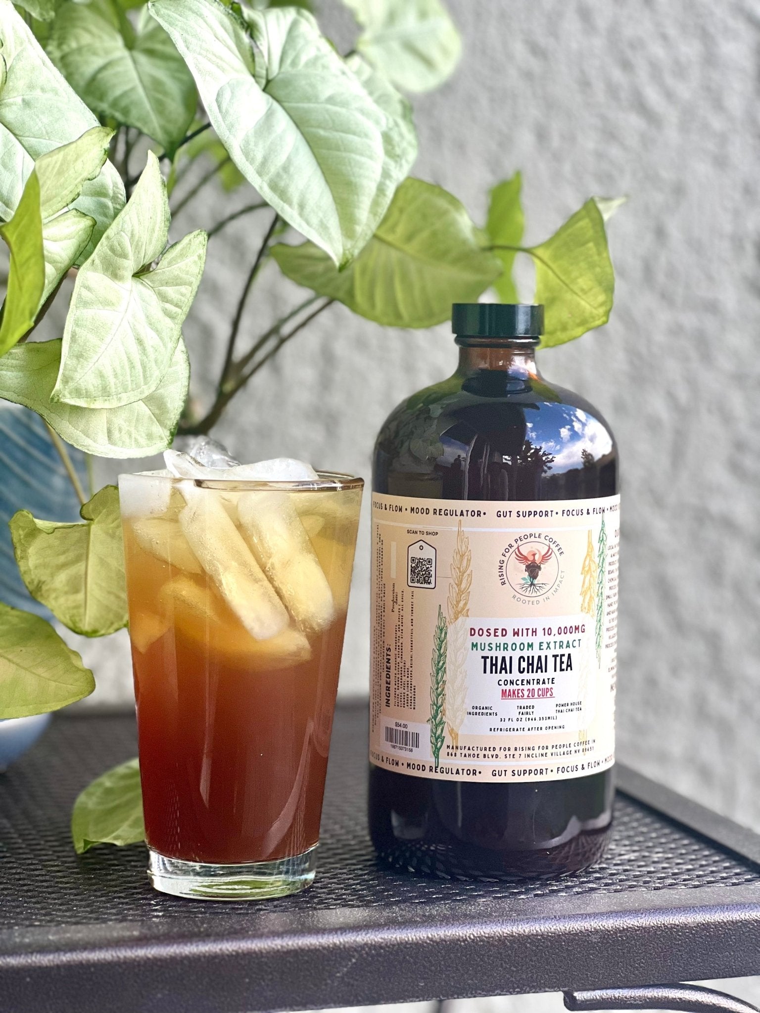 Happy Mushroom Thai Chai Tea concentrate in a glass bottle, featuring a colorful label with mushrooms and Thai-inspired design.