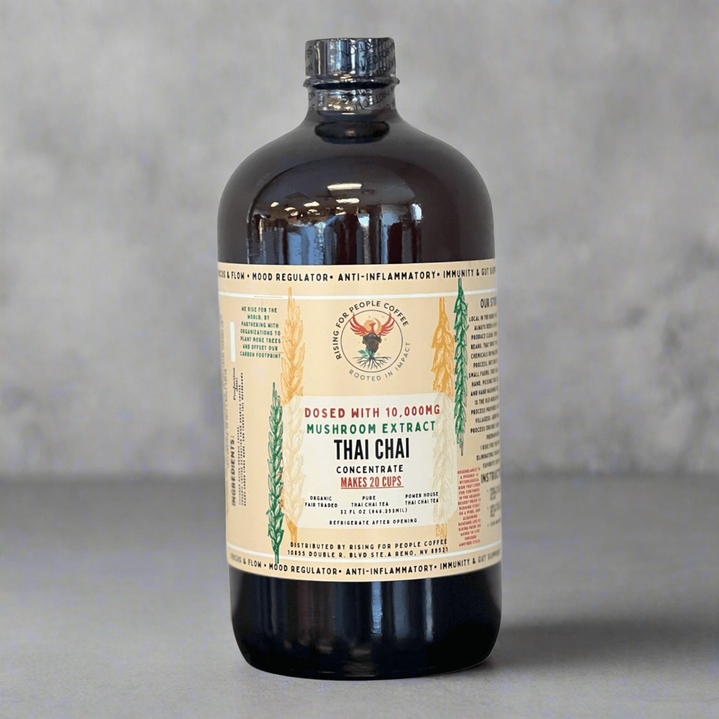 Bottle of Happy Mushroom Thai Chai Tea Concentrate by Rising For People Coffee Co. featuring a colorful label with tea and mushroom images.