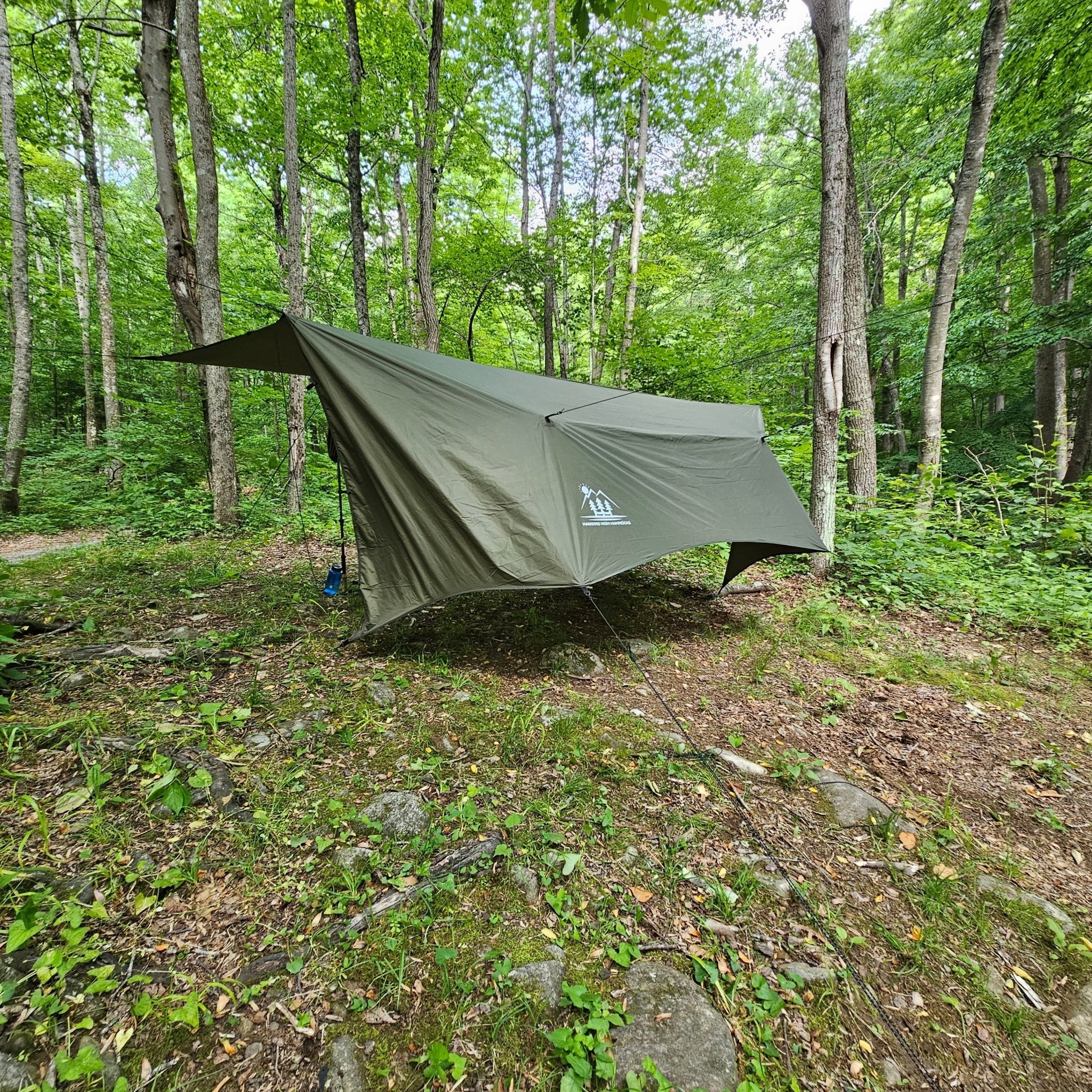 Hanging High Hammocks Hideaway Tarp, a 12-foot rain tarp for hammock camping, shown set up outdoors with trees in the background.