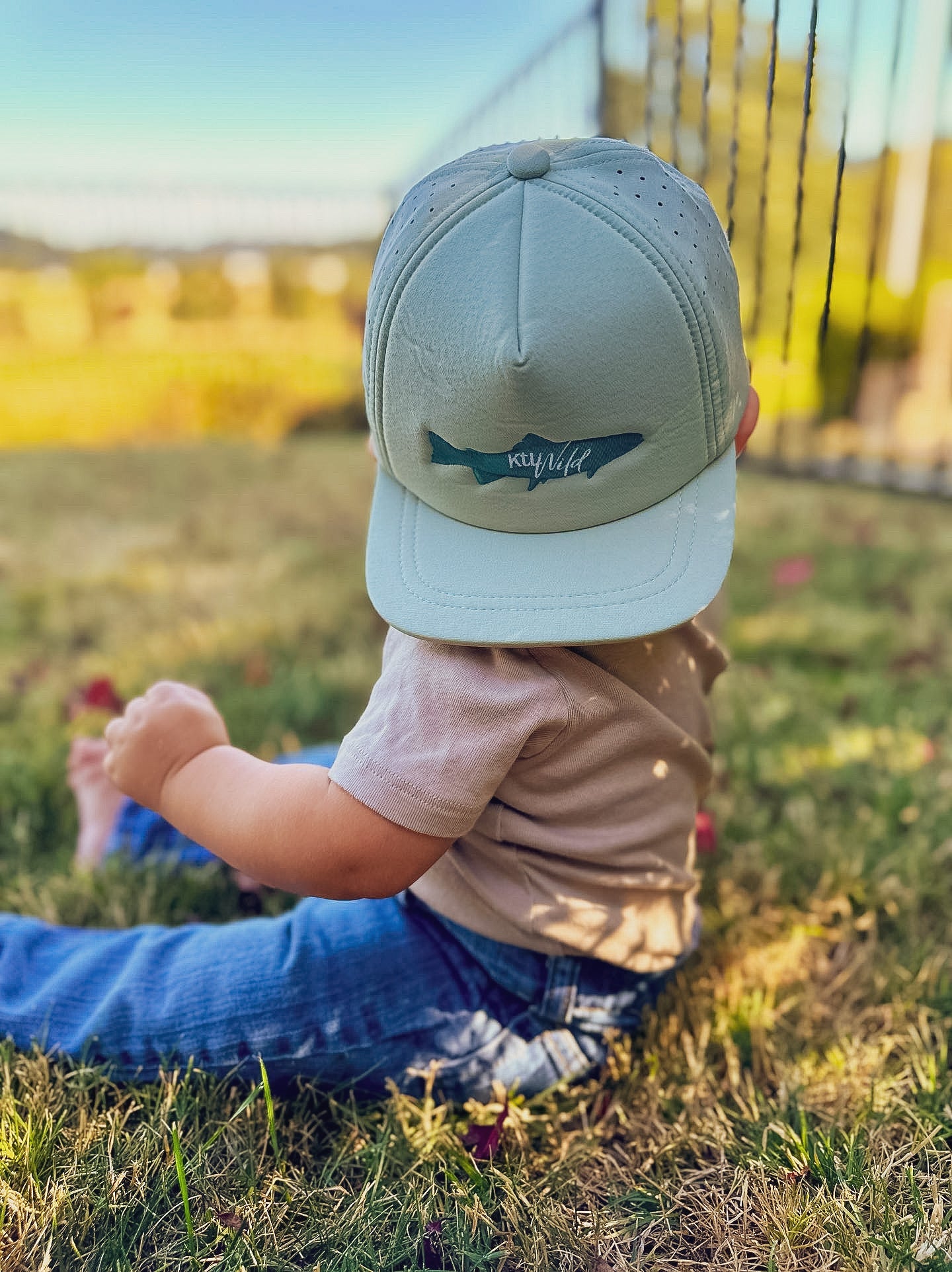 Keep the Littles Wild The Catch snapback hat with a curved brim and adjustable strap, featuring a bold embroidered logo on the front.