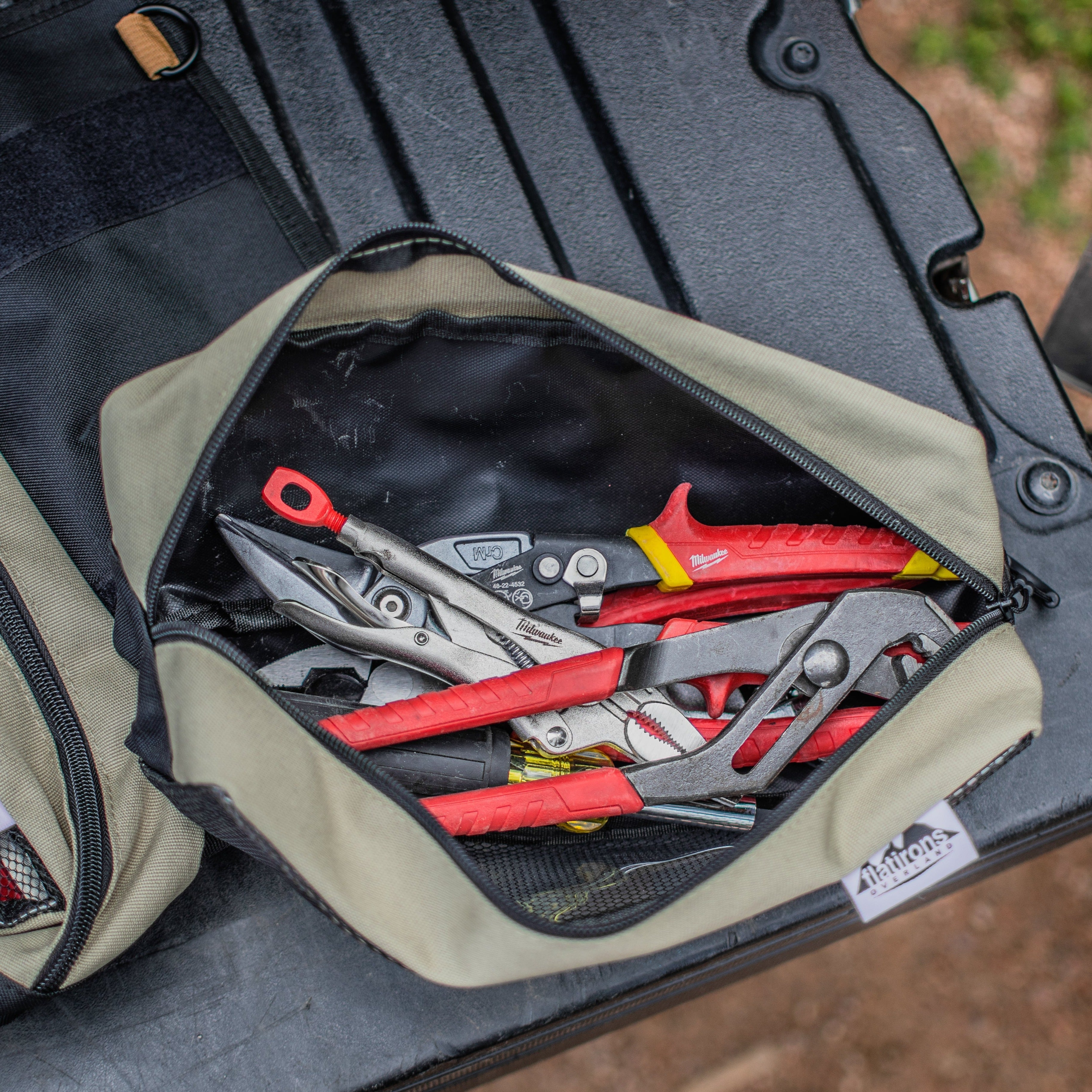 Flatirons Overland RiPouch™ Gear Roll with multiple compartments and durable fabric, shown rolled up with straps and gear inside.