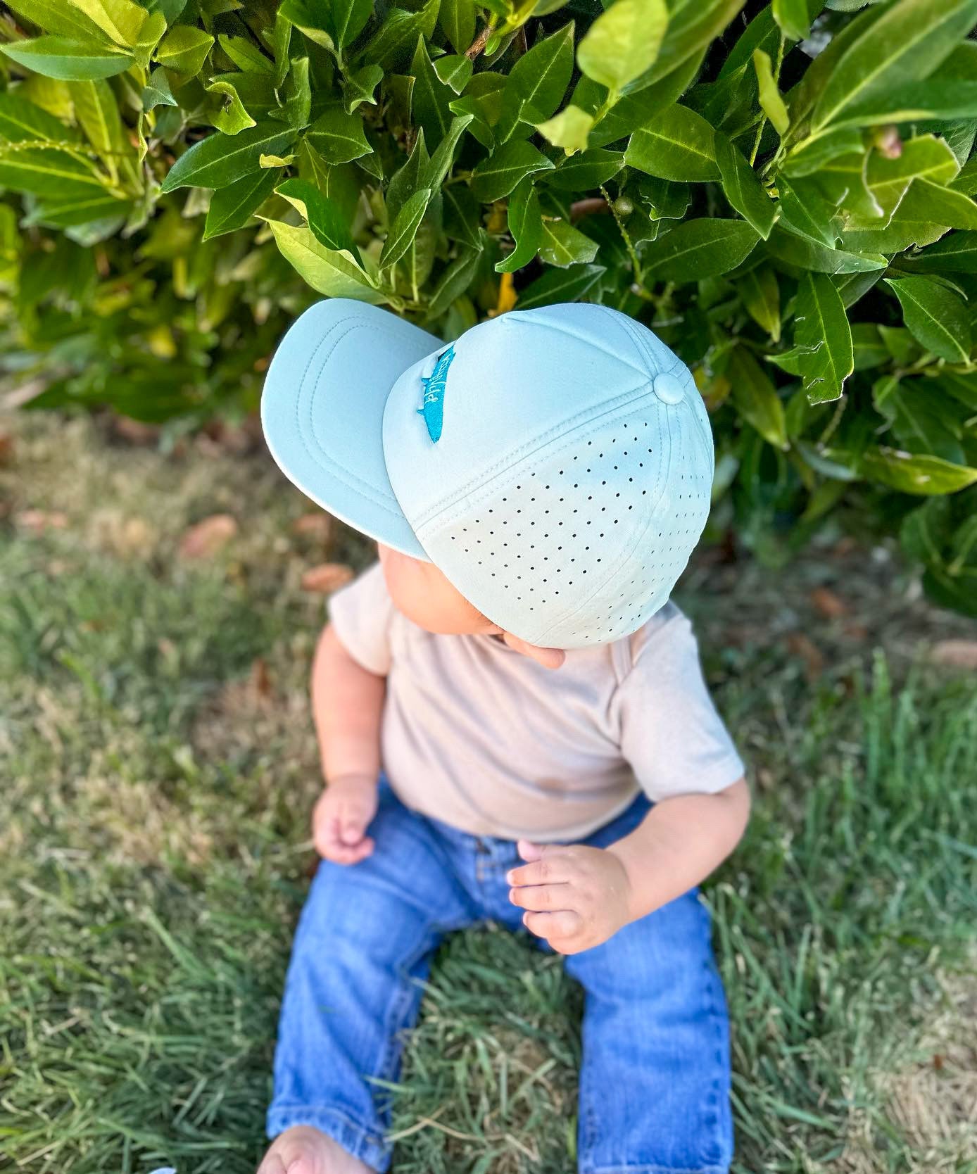 Keep the Littles Wild snapback hat featuring a bold embroidered logo and a flat brim in black and white.