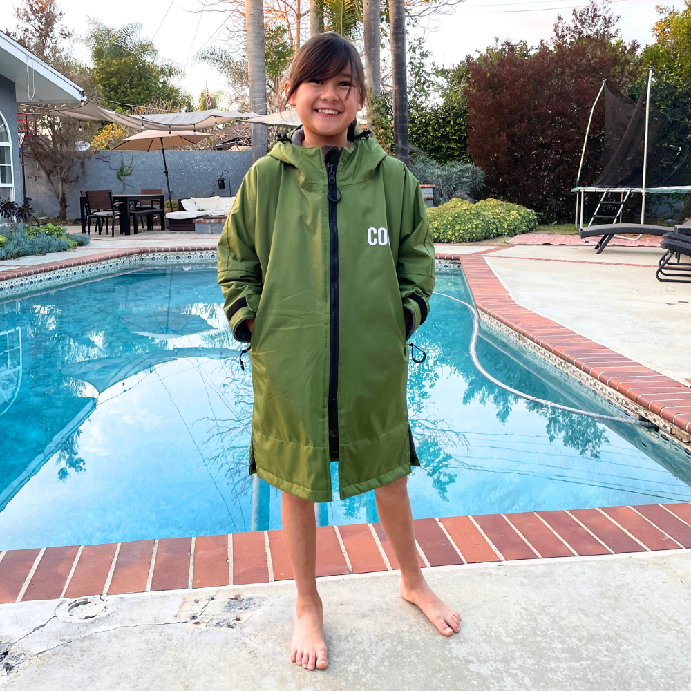 Kids waterproof swim parka in green from COR Surf, lightweight and protective for swimming and beach activities.
