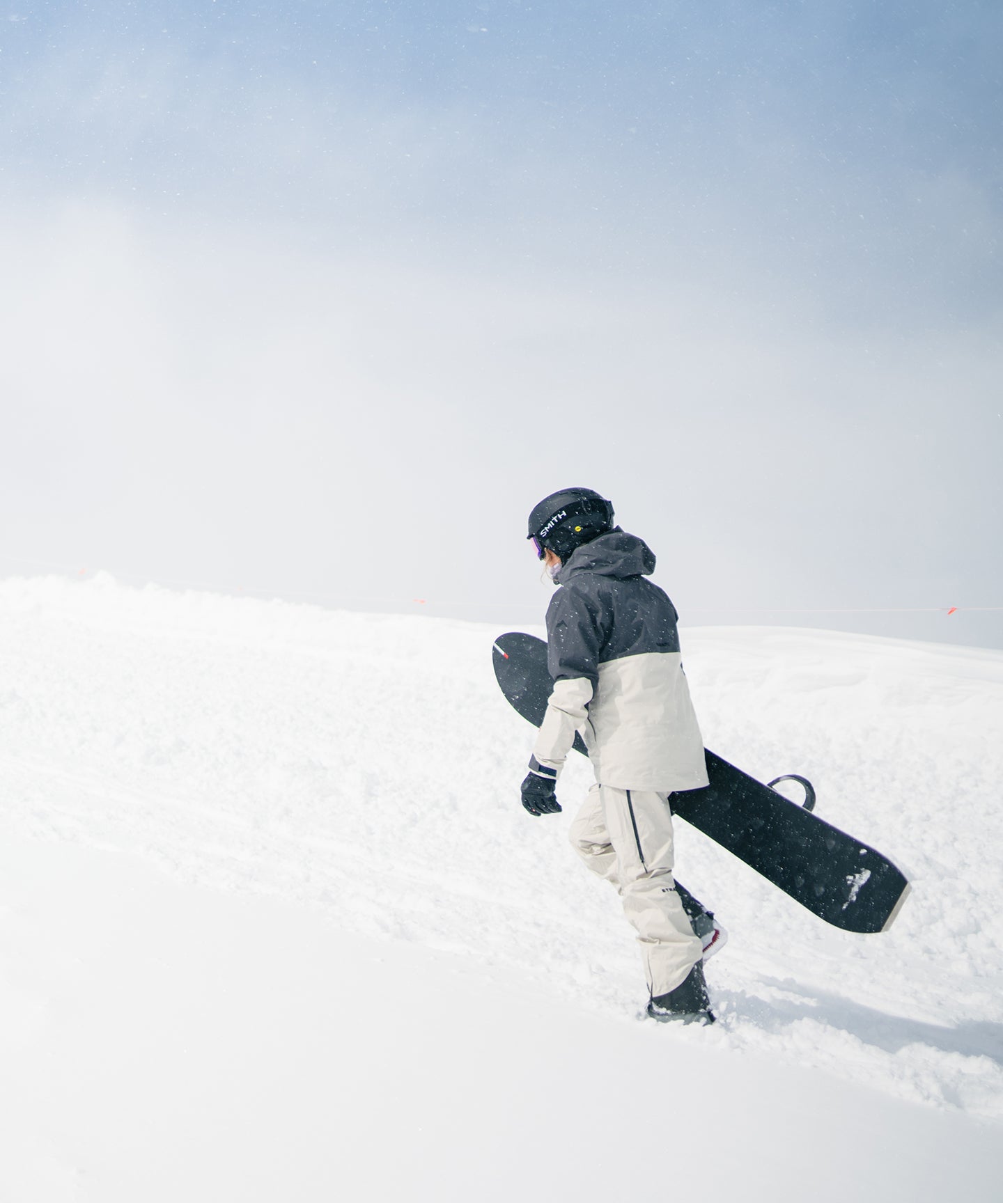 Strafe Outerwear Scarlett 3L Shell Bib pants in a meadow setting, showcasing waterproof fabric and adjustable straps.