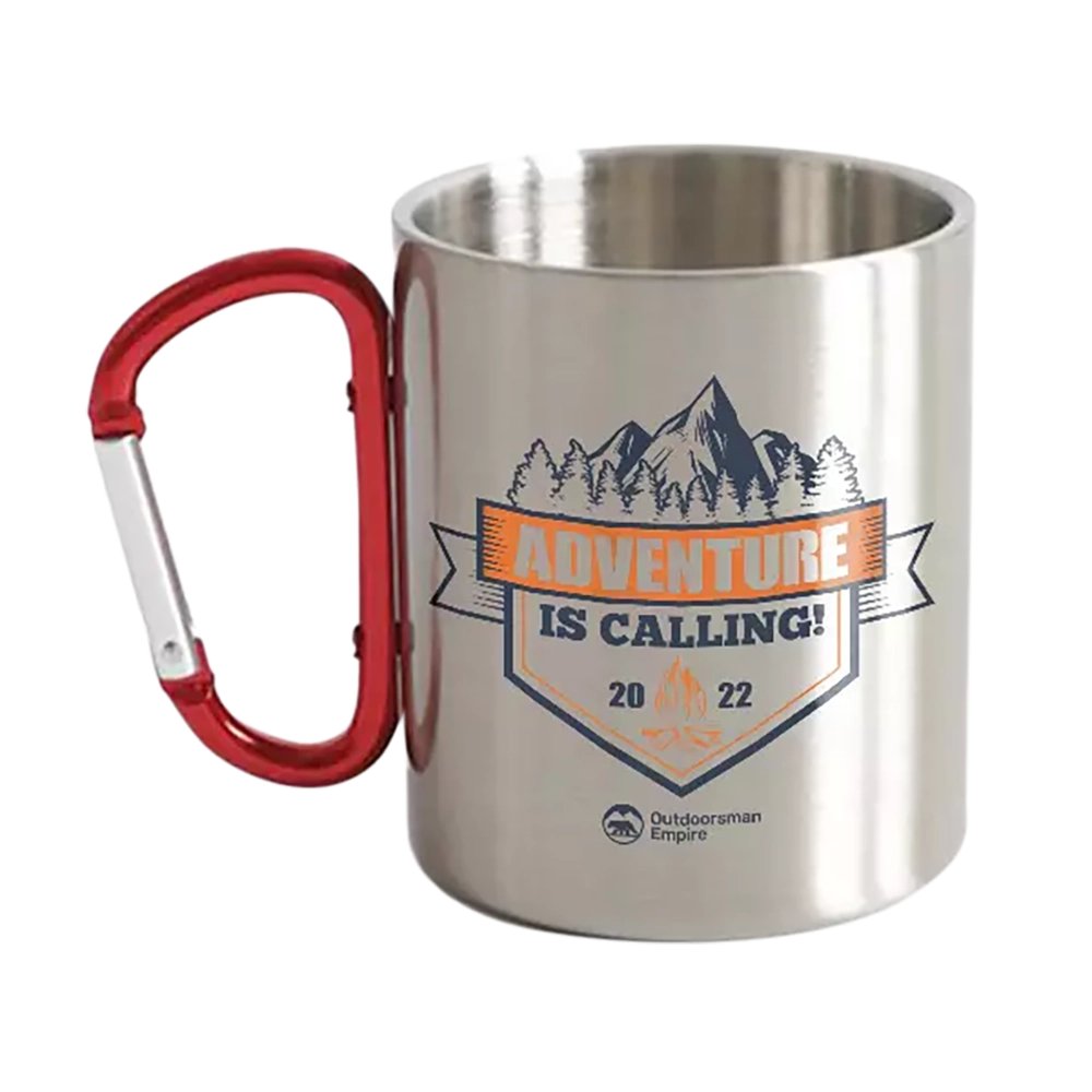 Outdoorzees Adventure Is Calling carabiner mug hanging from a backpack, showing durable metal construction and outdoor-ready design.