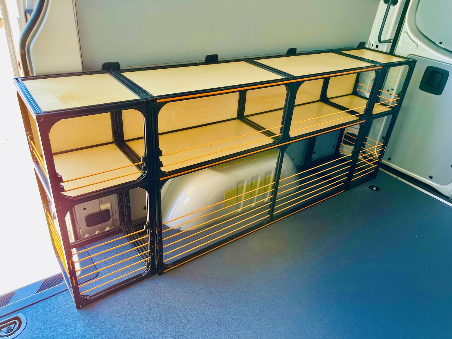 Mercedes Sprinter 144 camper van conversion shelving set by TNTvans, featuring orange storage shelves inside a Mercedes Sprinter van.
