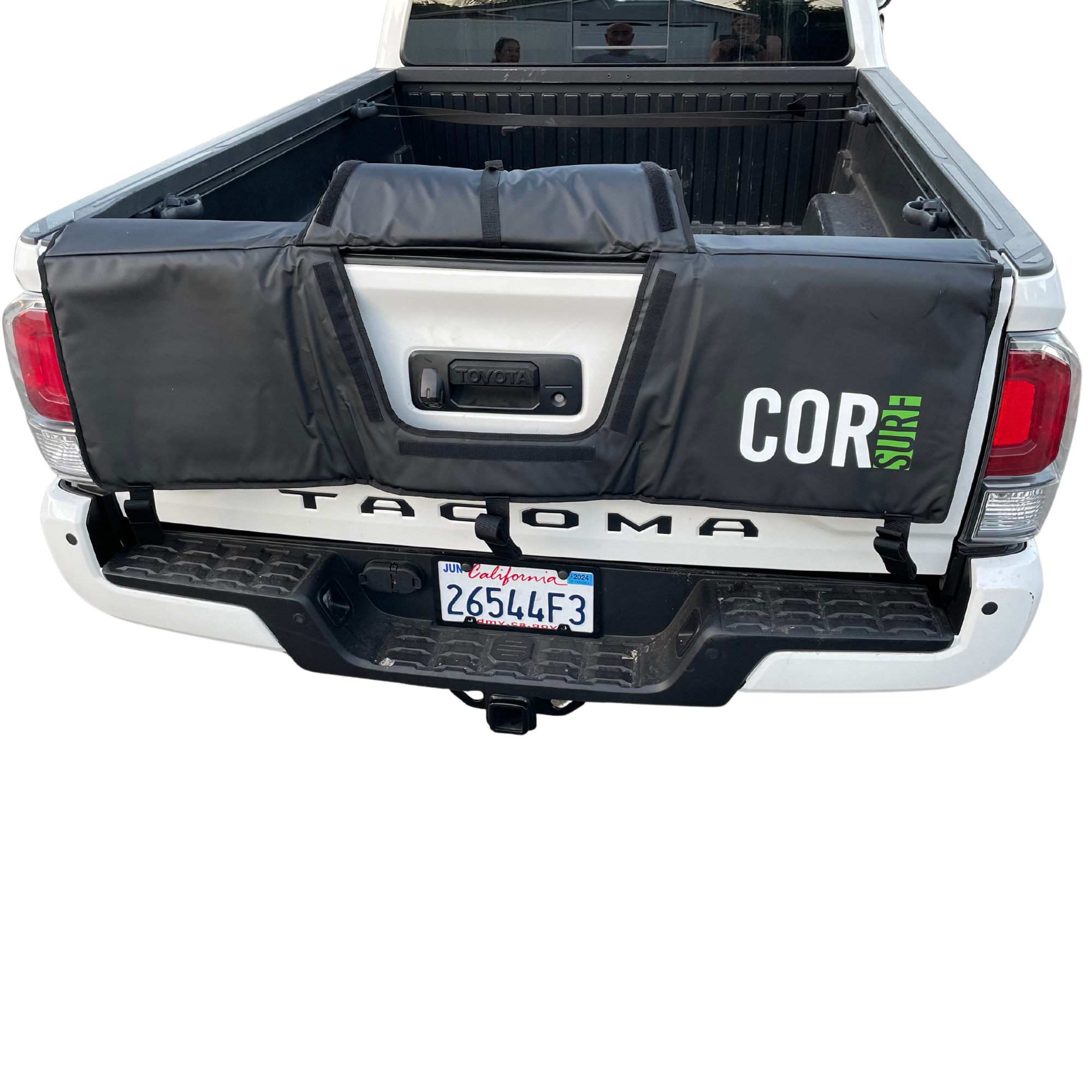 Mid-size truck tailgate pad by COR Surf holding bikes and surfboards, with padded straps for secure transport.