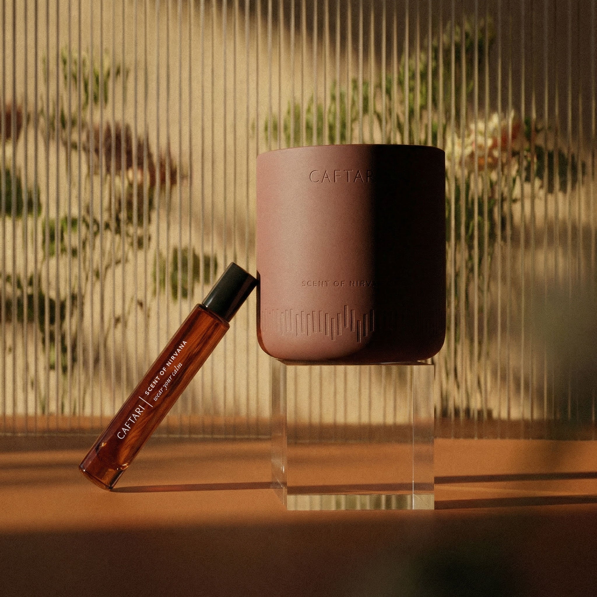Caftari Scent of Nirvana rollerball perfume and candle bundle in a fluted glass container, showcasing elegant design.