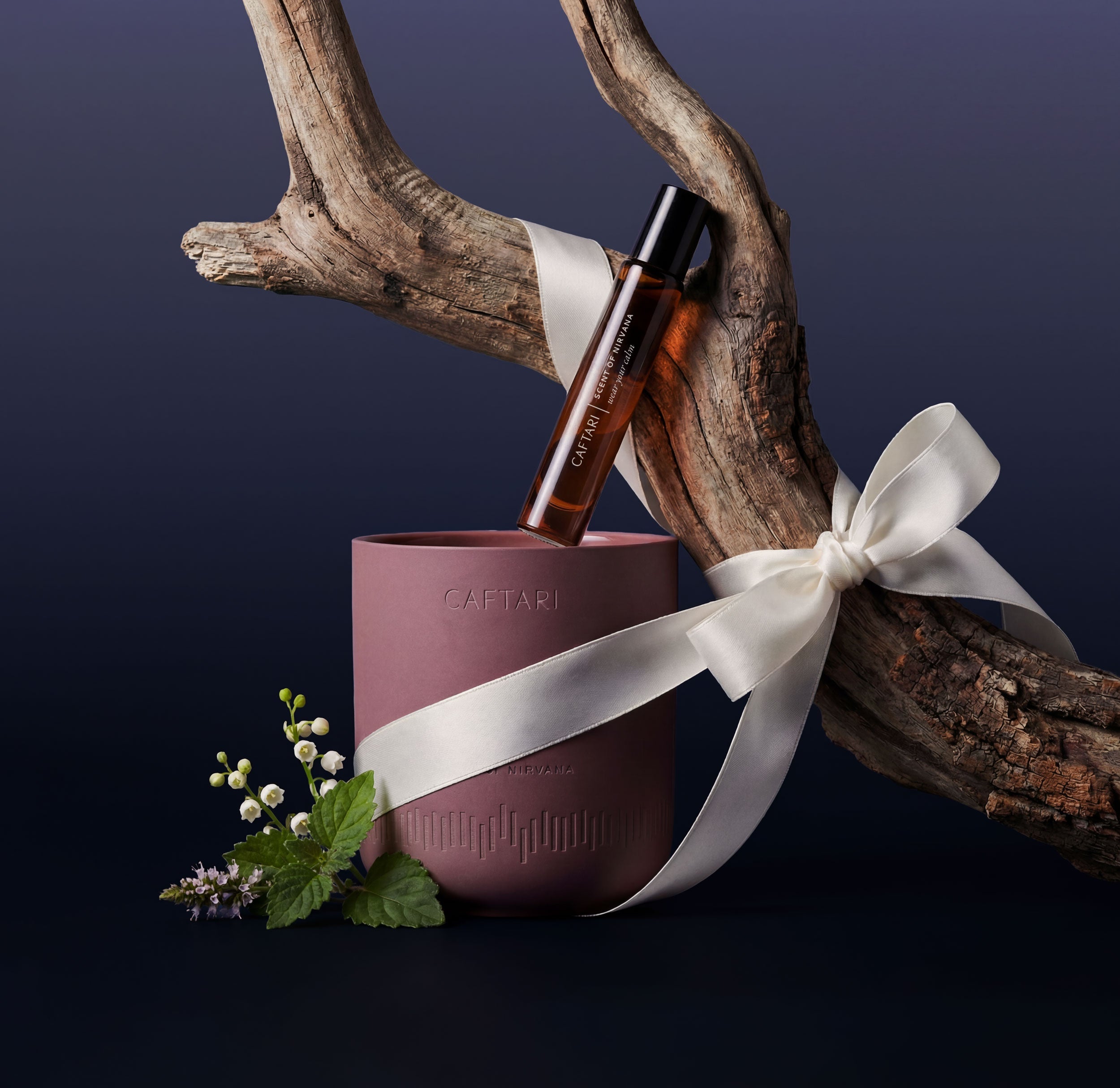 Caftari Nirvana fragrance rollerball and candle bundle with ribbon, showcasing elegant packaging and soothing scent.