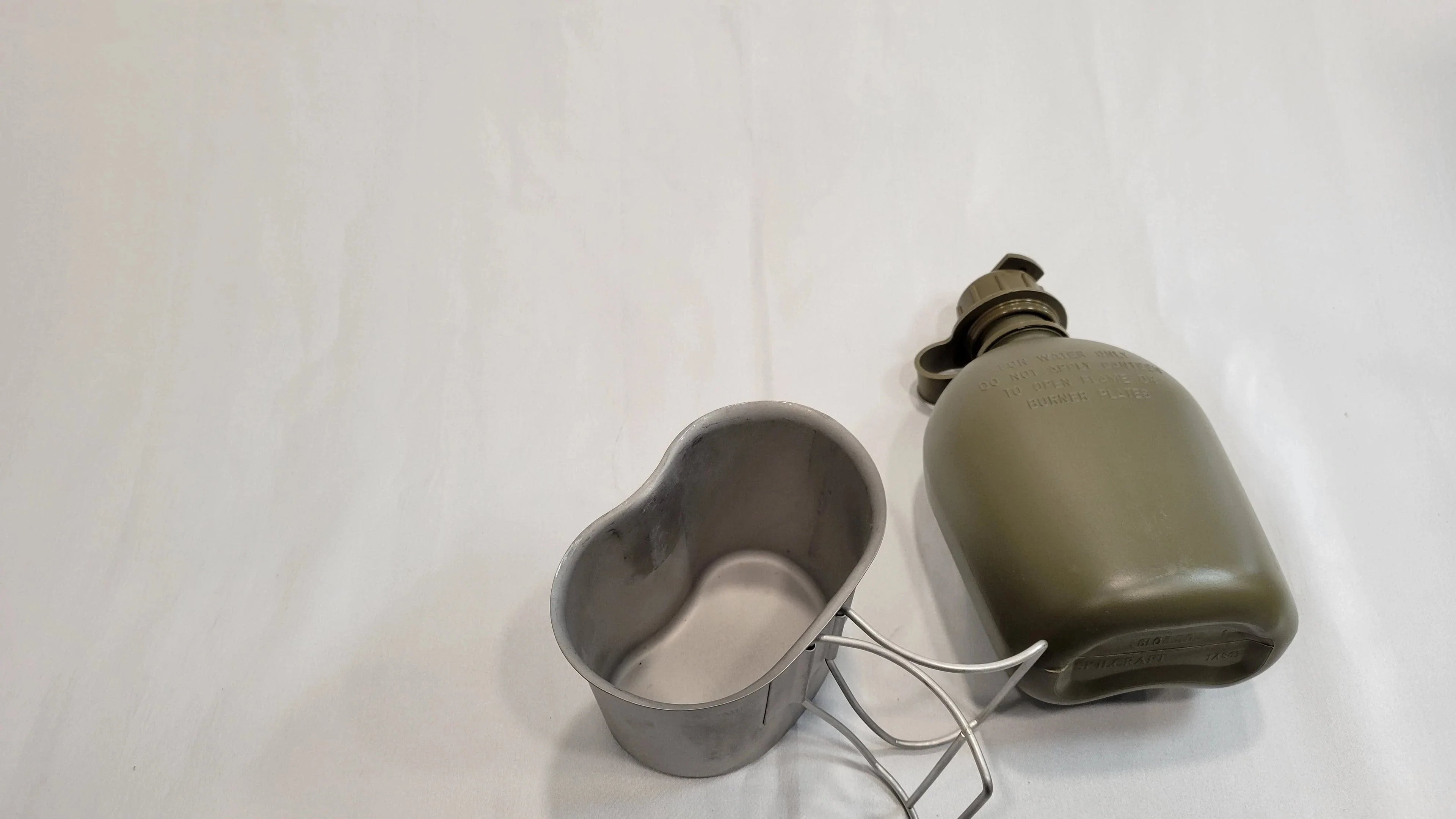 Onethiefsurplus 1 Qt Canteen with matching cup, canteen cup stove, and stand in a compact outdoor camping gear set.