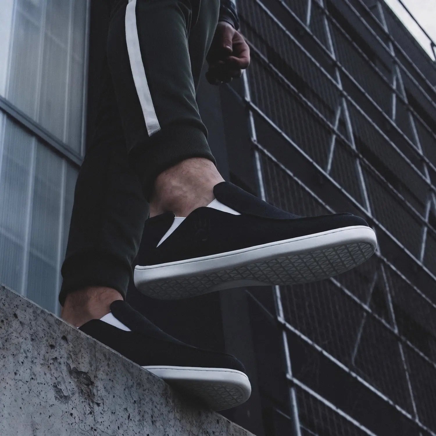 Bearfoot Oso CG2 shoe in black and white with black suede upper, slip-on style, featuring sleek design and contrast color details.