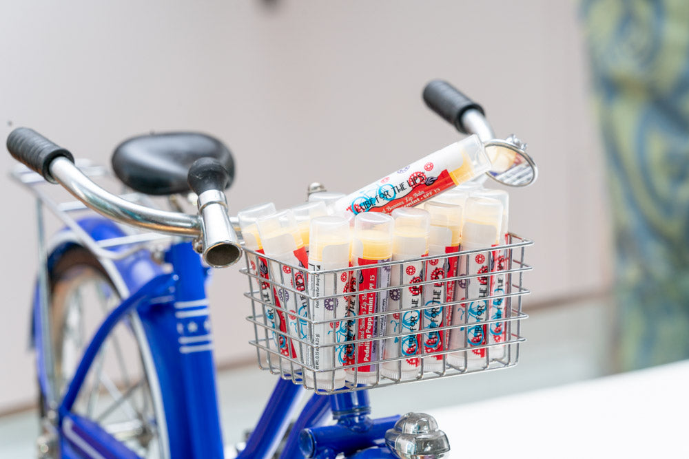 Essential Journeys Pedaling Peppermint SPF 15 lip balm in a bike-themed tube, perfect for moisturizing and sun protection for lips.