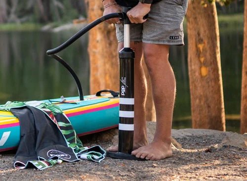 Backcountry Sportsman 11'0" Yacht Hopper inflatable paddleboard in mint, teak, and blue with pump and accessories visible.