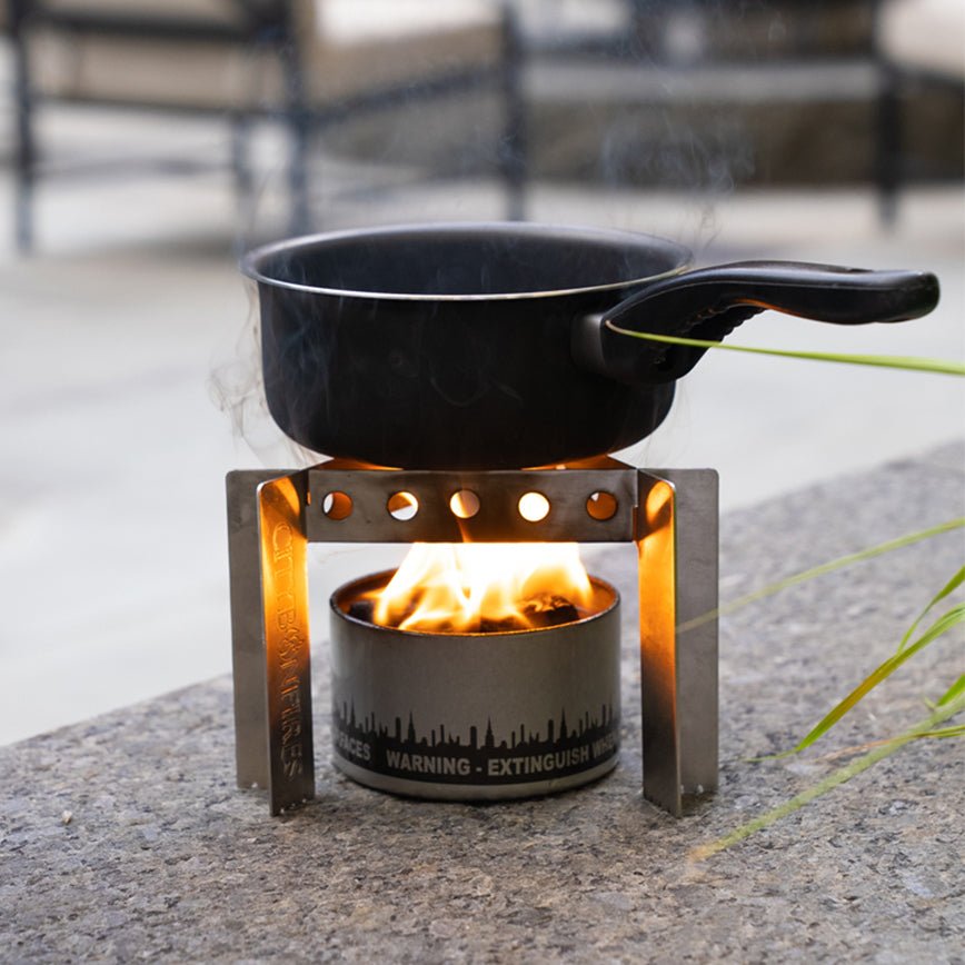 City Bonfires portable camp stove with stand, set up outdoors ready for cooking over an open flame.