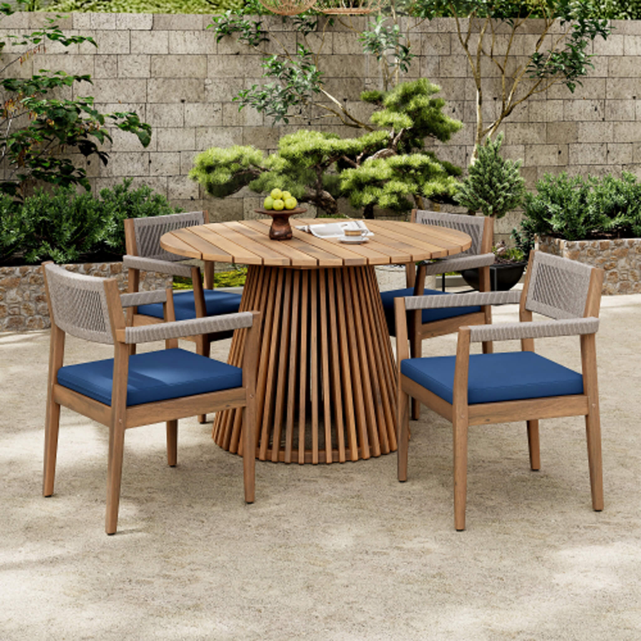 5-piece outdoor acacia wood patio furniture set with braided dining chairs and navy cushions, featuring a dining table.