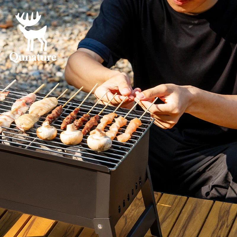 Foldable Qunature Global BBQ grill stove with durable chrome-plated net and ventilation for outdoor grilling.