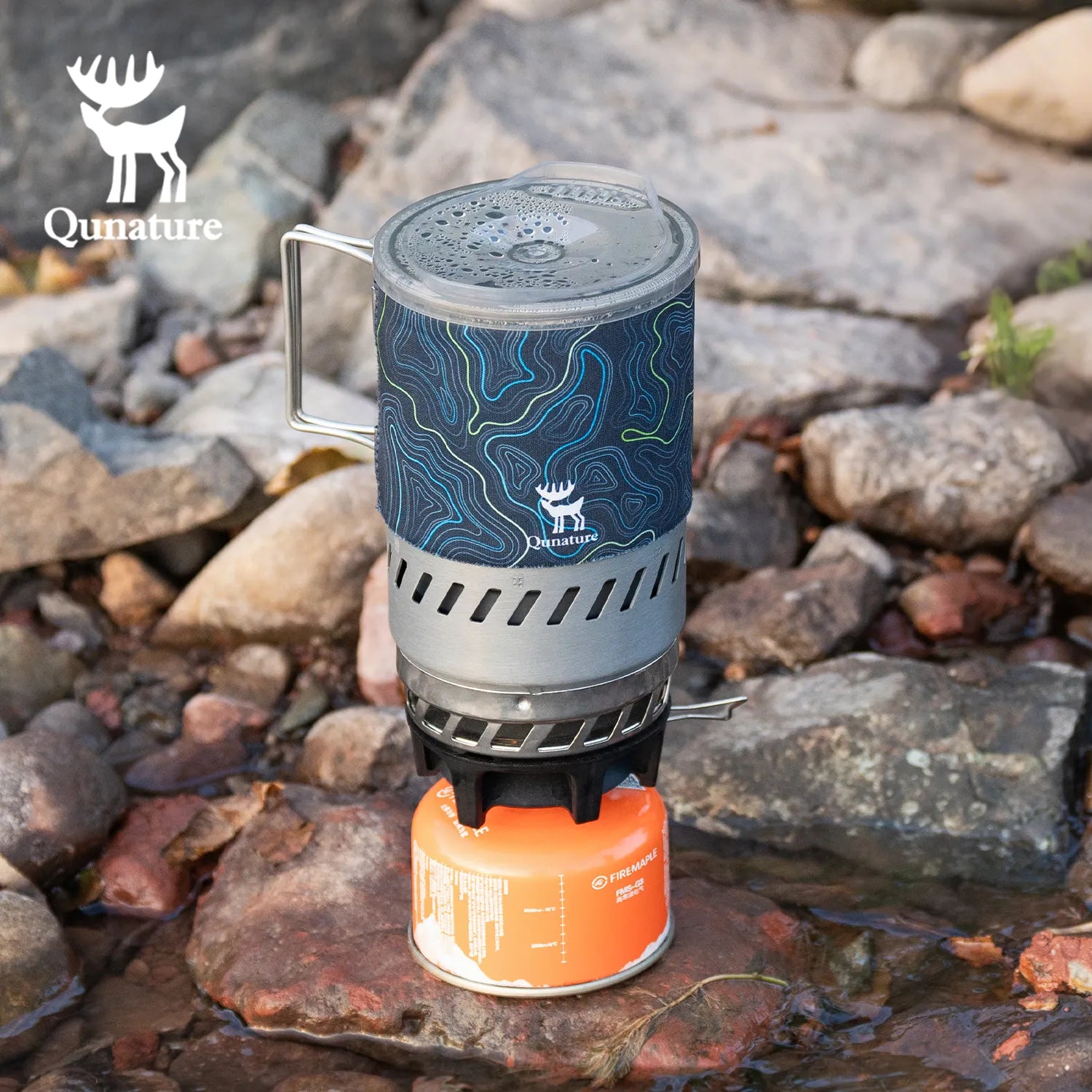 Qunature Global integrated heat collection stove system for camping, hiking, and outdoor adventures in natural setting.