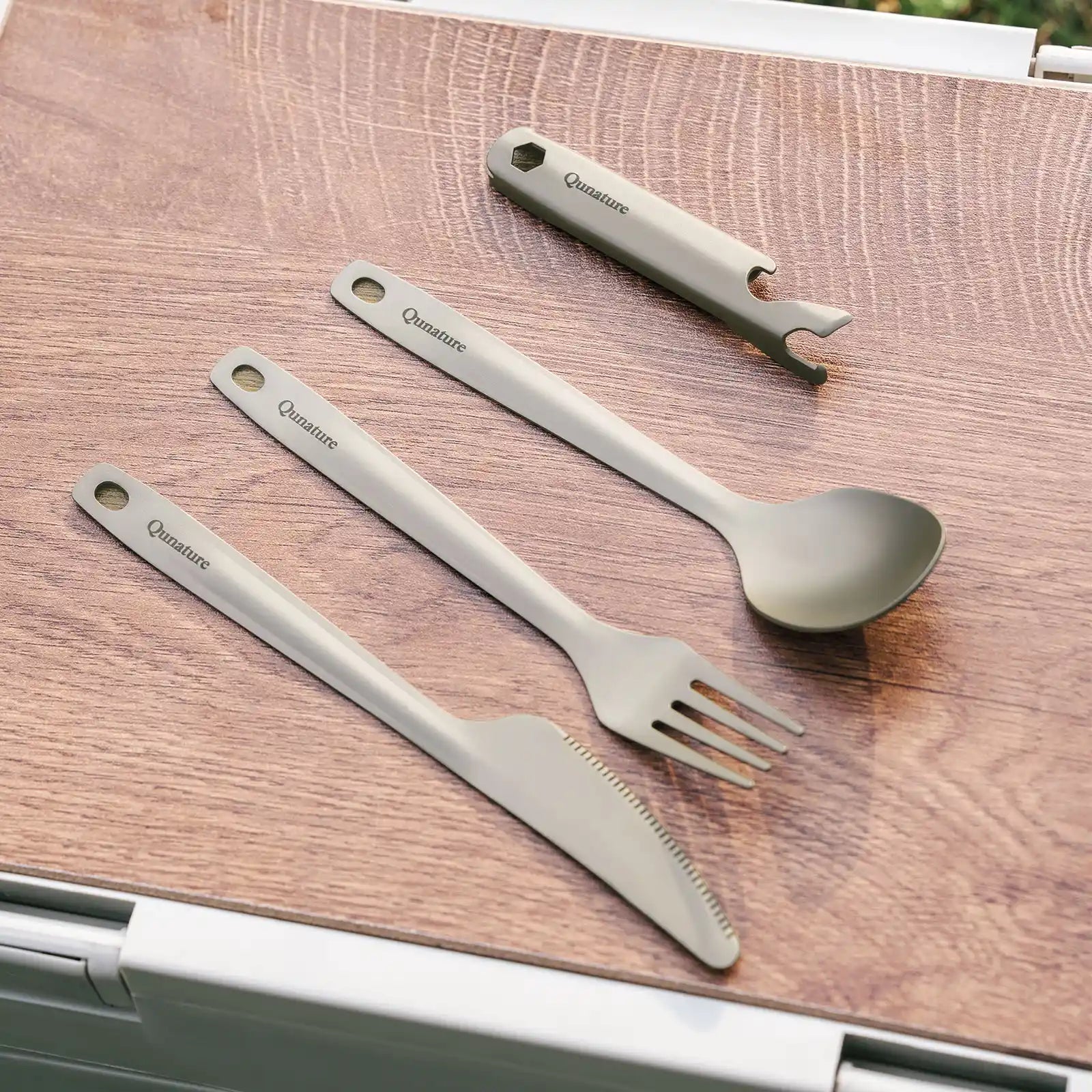 Lightweight Qunature Global titanium 4-piece tableware set including bowls, plates, and utensils on a wooden surface.