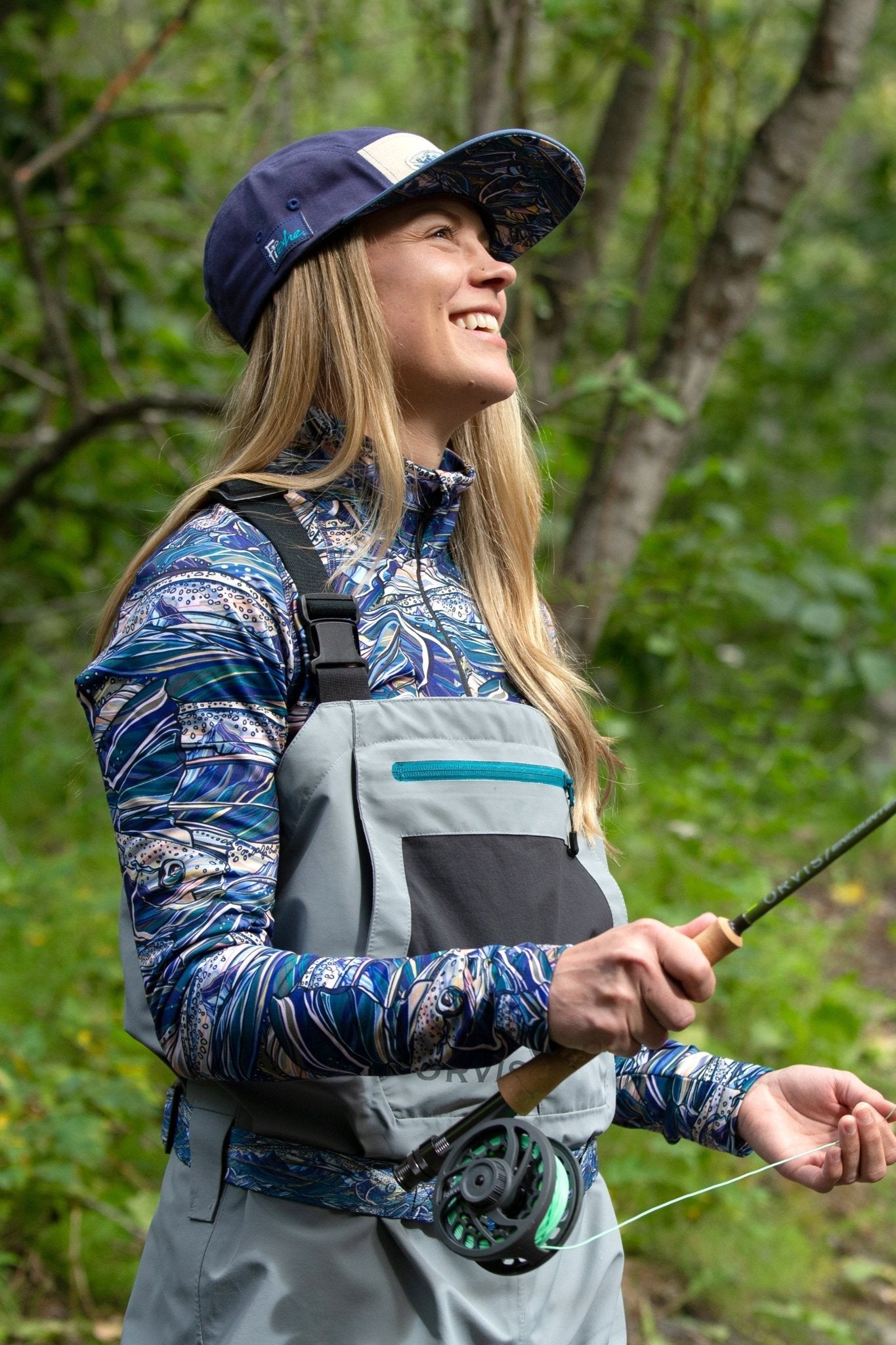 FisheWear Rainbow Ridge Thermal 1/4 Zip Top in vibrant rainbow colors, made from warm thermal fabric, displayed on a hanger.