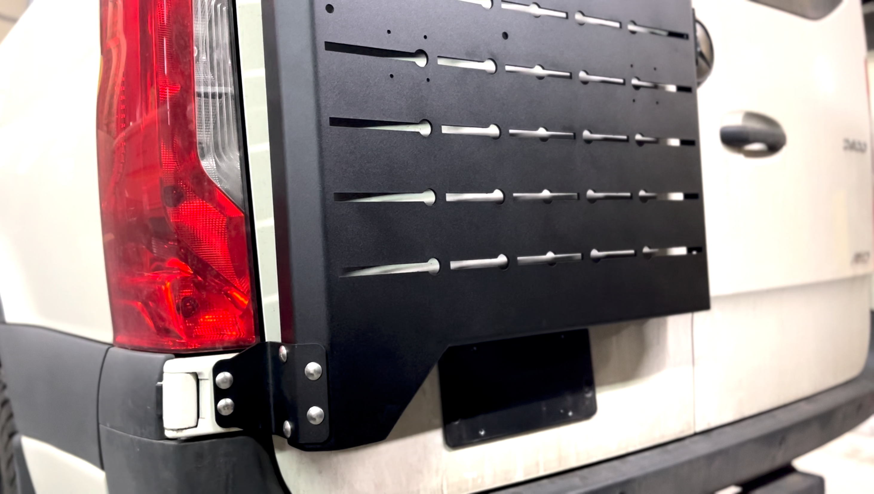 Avatar Offroad Sir Packs-a-lot storage mount attached to a vehicle's rear door for secure box carrying and organization.