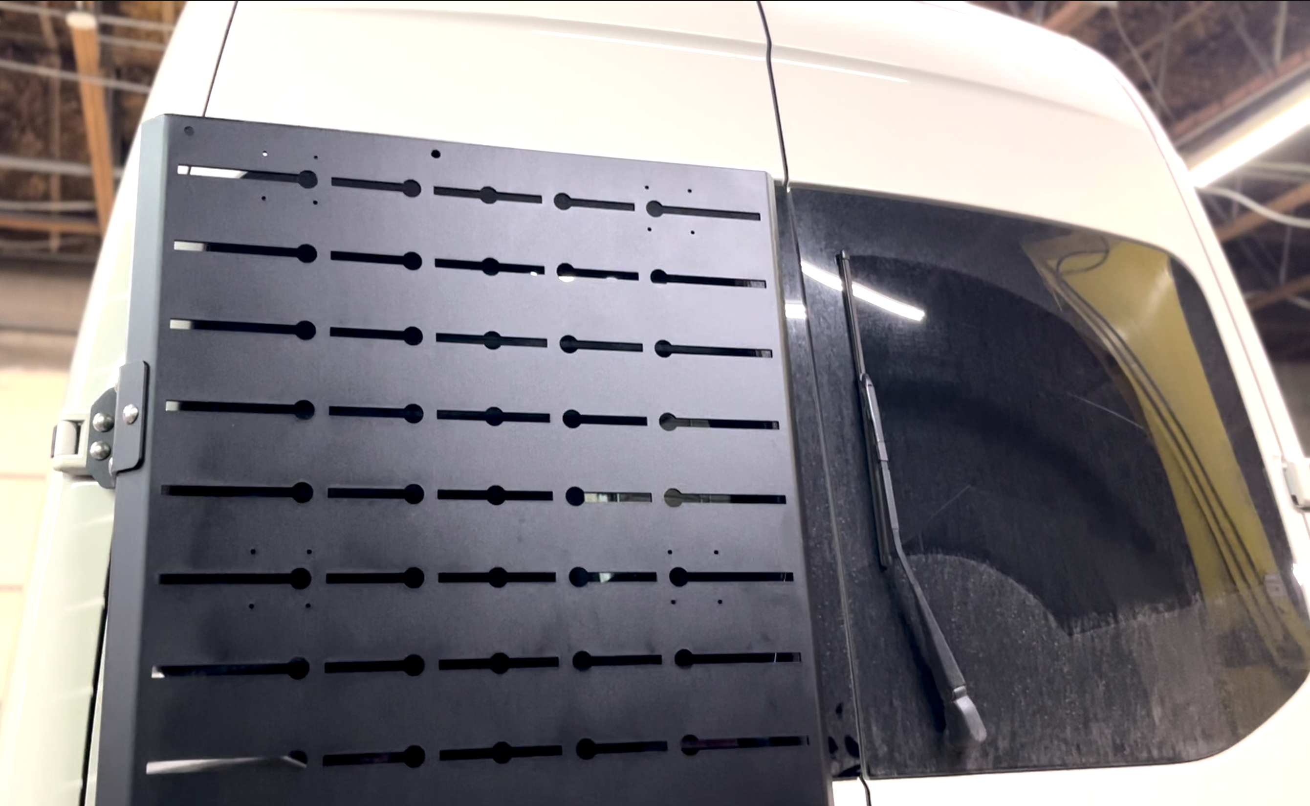 Avatar Offroad Sir Packs-a-lot storage mount attached to the rear door of a Sprinter van for organized gear storage.