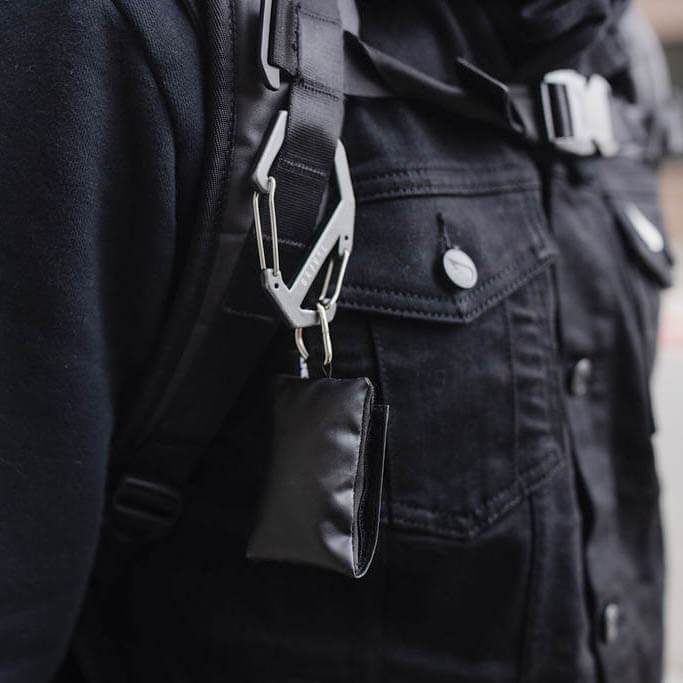 Gray Gravel carabiner attached to a backpack, showing its sturdy design and lightweight construction.