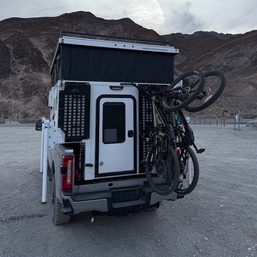 Lolo Racks bike rack kit mounted on van cargo Molle panel, designed for secure bike transport and versatile cargo organization.