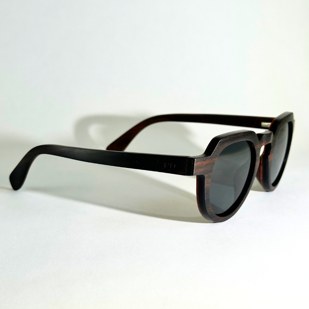 Eastern Outer Wallsburg sunglasses with round wood and carbon fiber frames, shown from a right-angle view.