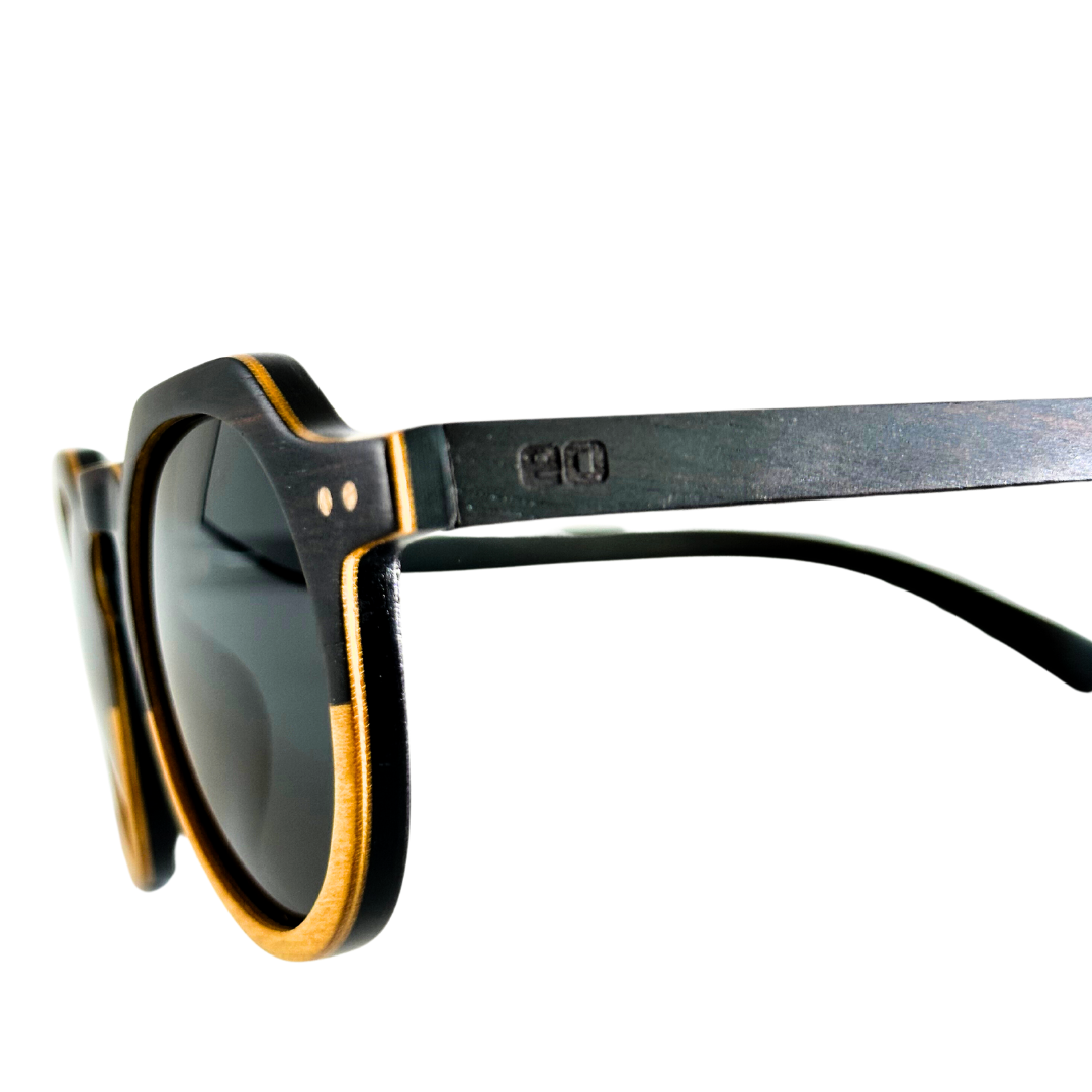 Eastern Outer Wallsburg sunglasses with round yellow lenses and wood and carbon fiber frames, close-up view.