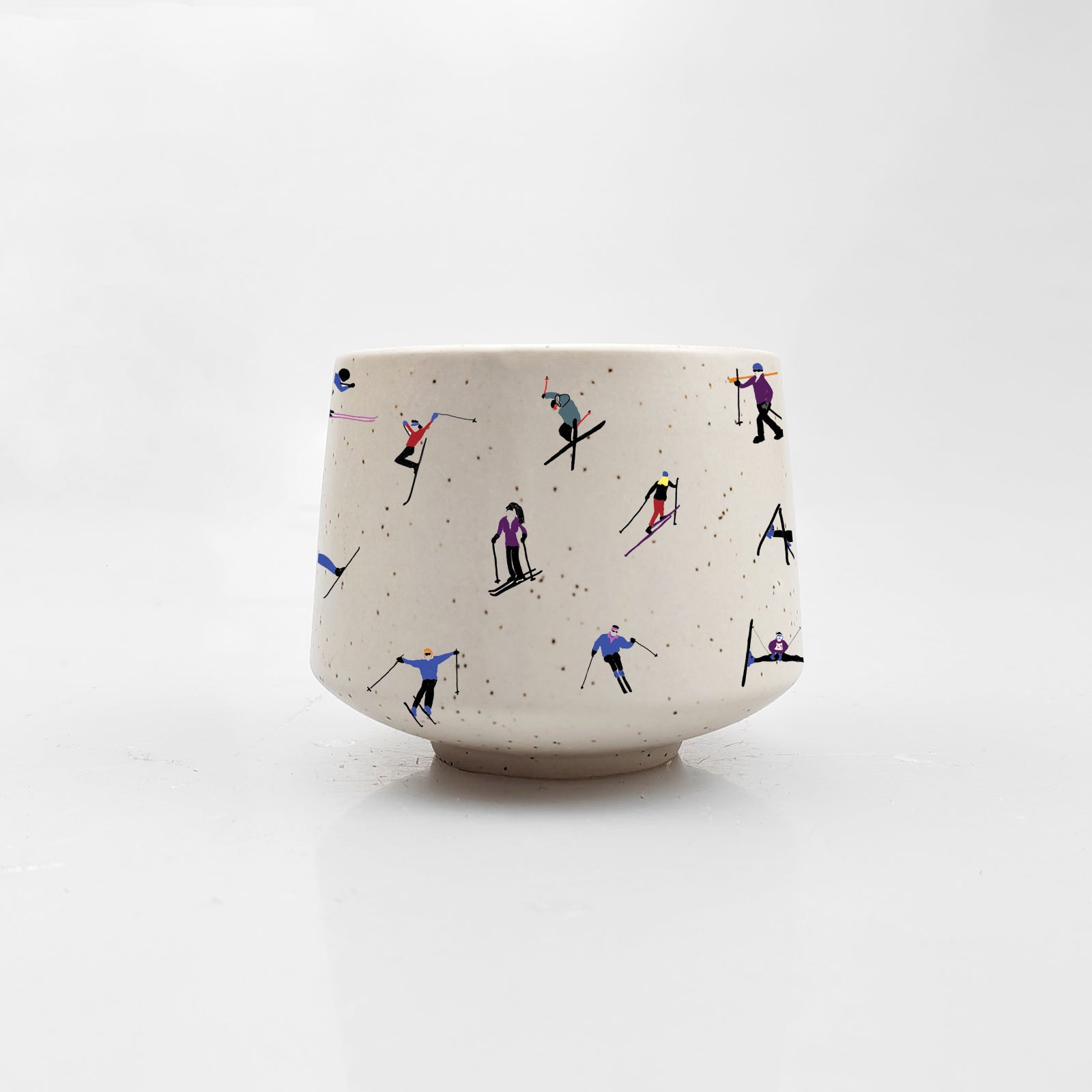 Mini ceramic skier cup by Artsy Em's Designs featuring a colorful skier illustration on a white background.