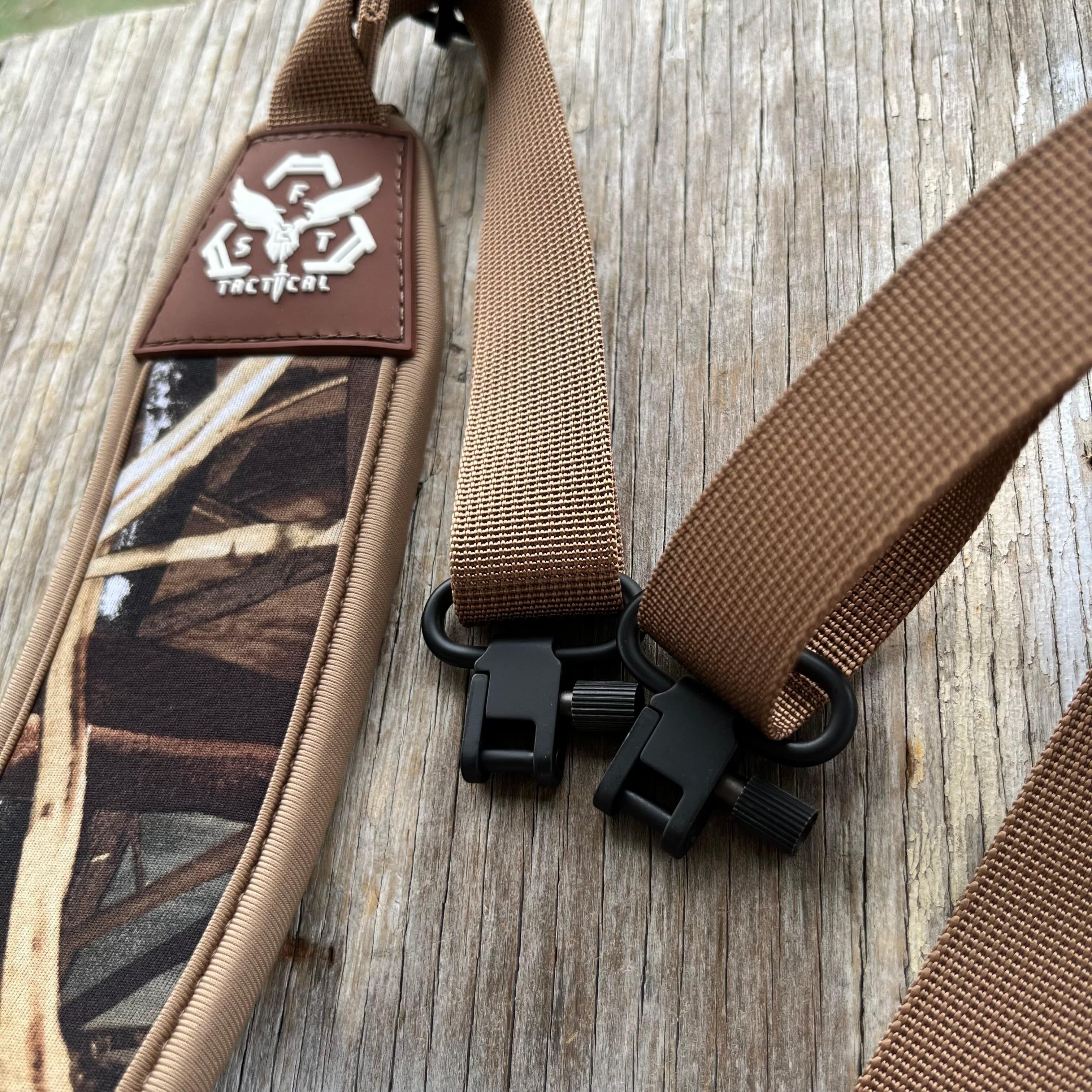 SFT2 Tactical hunting sling attached to a rifle, adjustable strap with padded shoulder support for outdoor hunting activities.