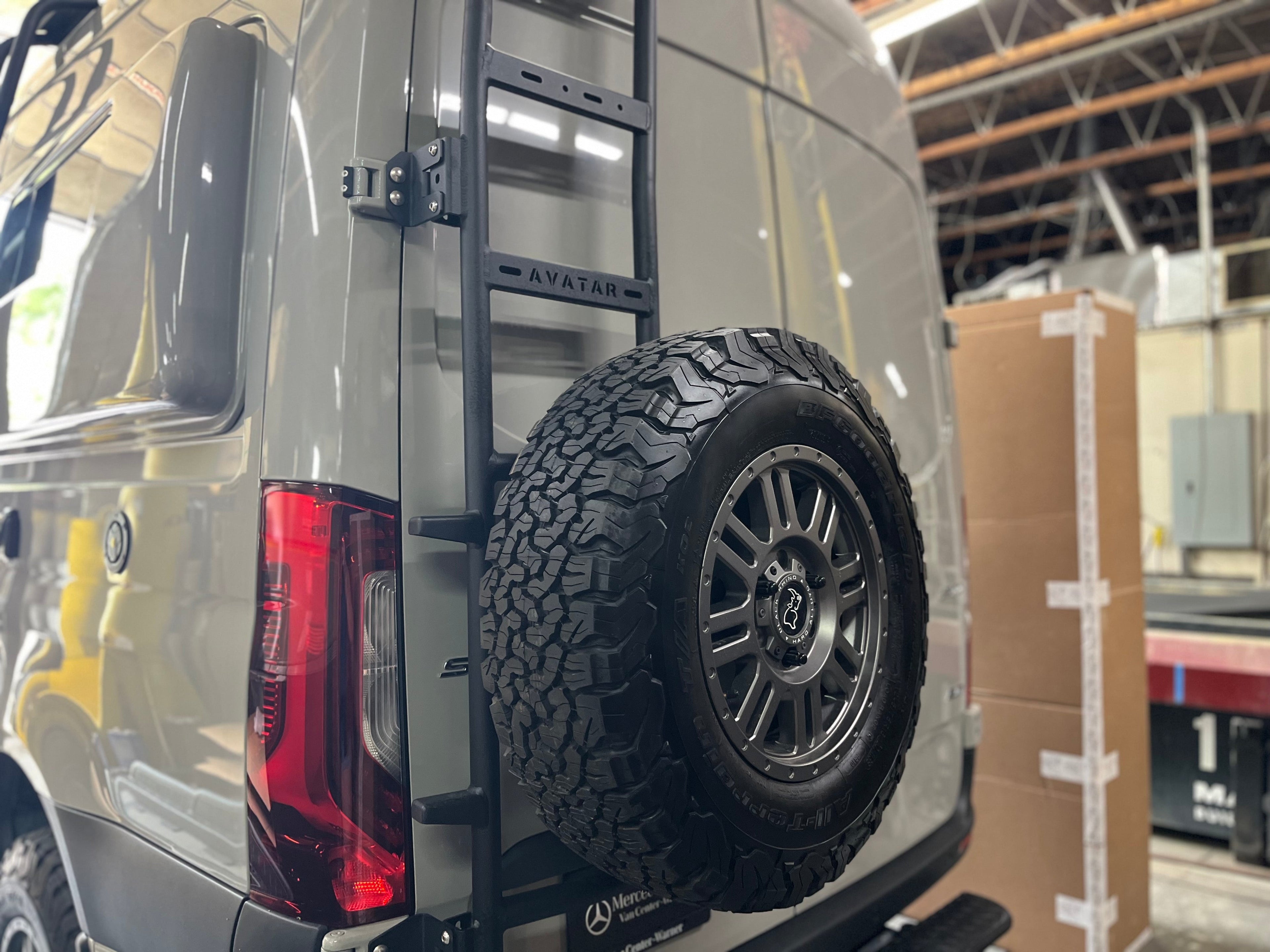Avatar Offroad rear ladder tire carrier mount attached to a vehicle, featuring a sturdy metal design for off-road tire carrying.