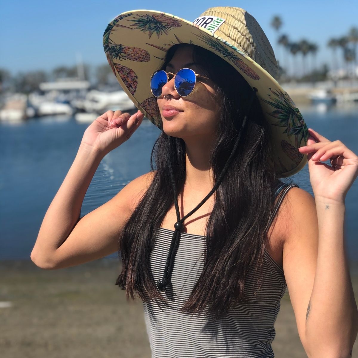 Side view of COR Surf straw lifeguard sun hat for adults, featuring wide brim and woven straw design for sun protection.