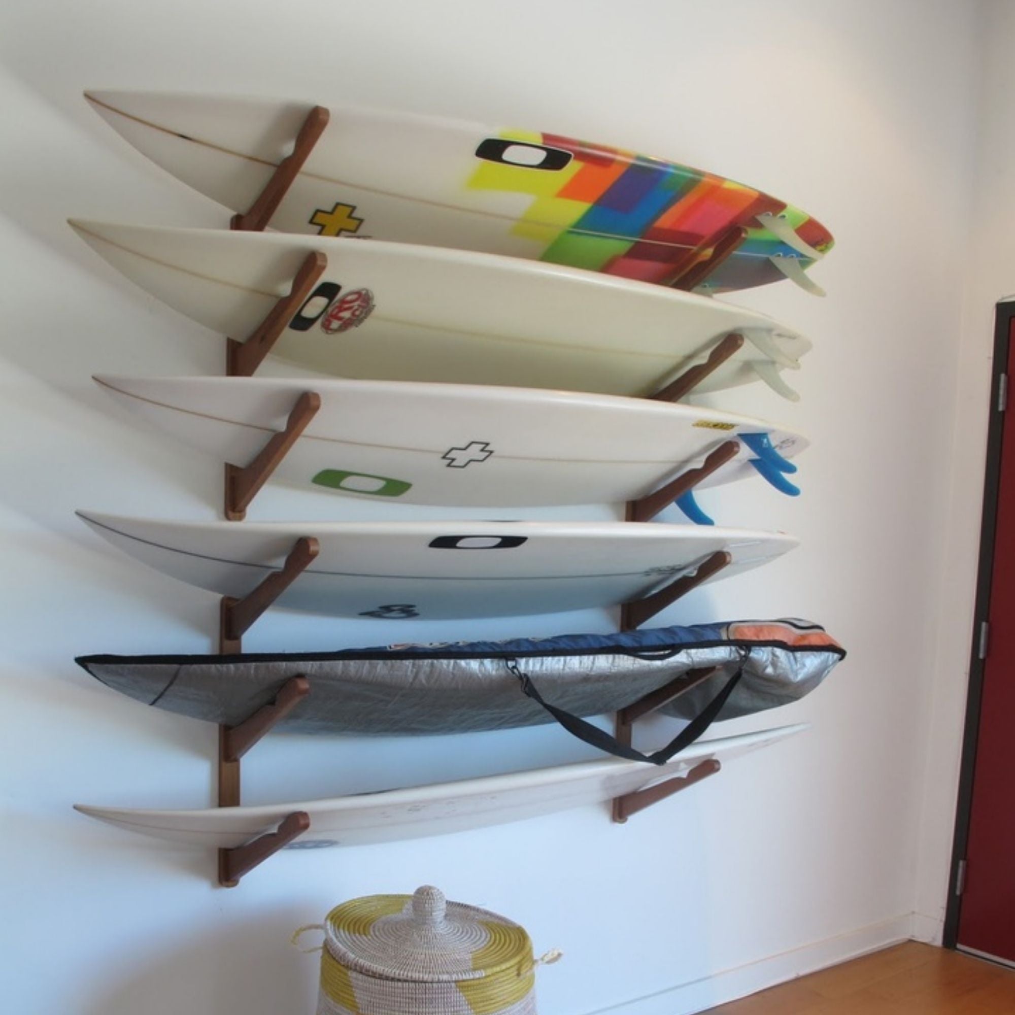 COR Surf triple bamboo wall rack holding three surfboards, wakeboards, and snowboards for organized storage.