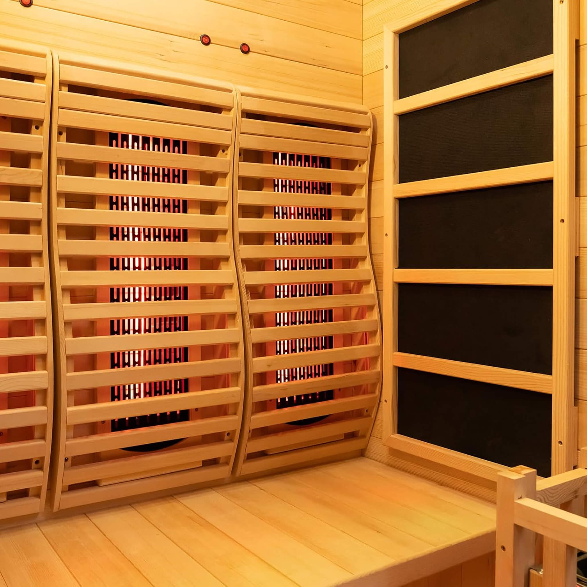 Inside view of Rövia Luma 2-Person indoor hybrid sauna with seats, infrared panels, and steam heater for relaxing wellness.