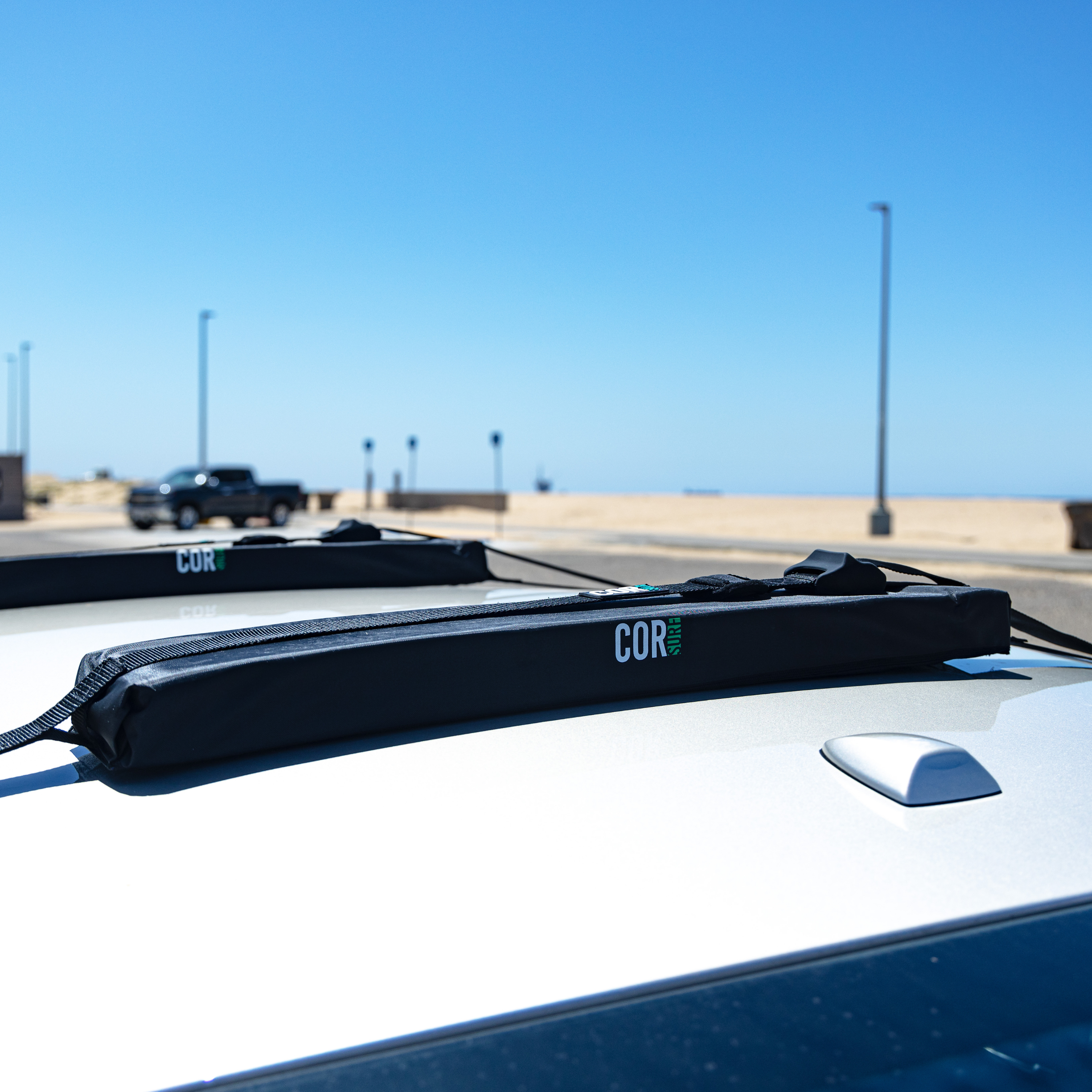 COR Surf universal soft car roof rack for surfboards, SUPs, kayaks, and canoes, securely attached to vehicle roof.