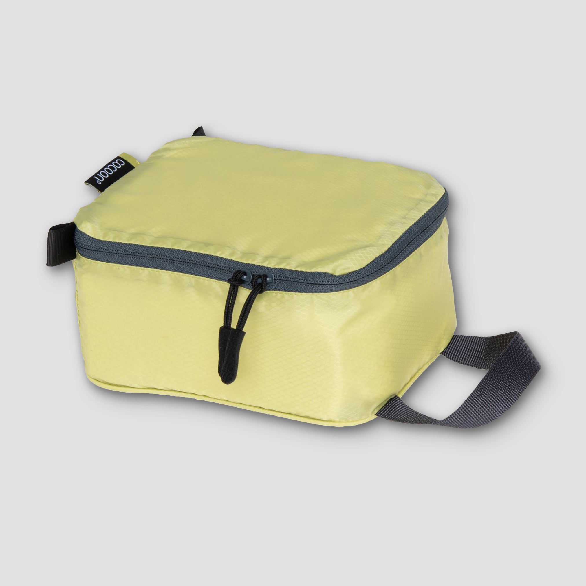 COCOON Discrete Light Packing Cubes travel organizers in various colors, compact and lightweight for efficient packing.