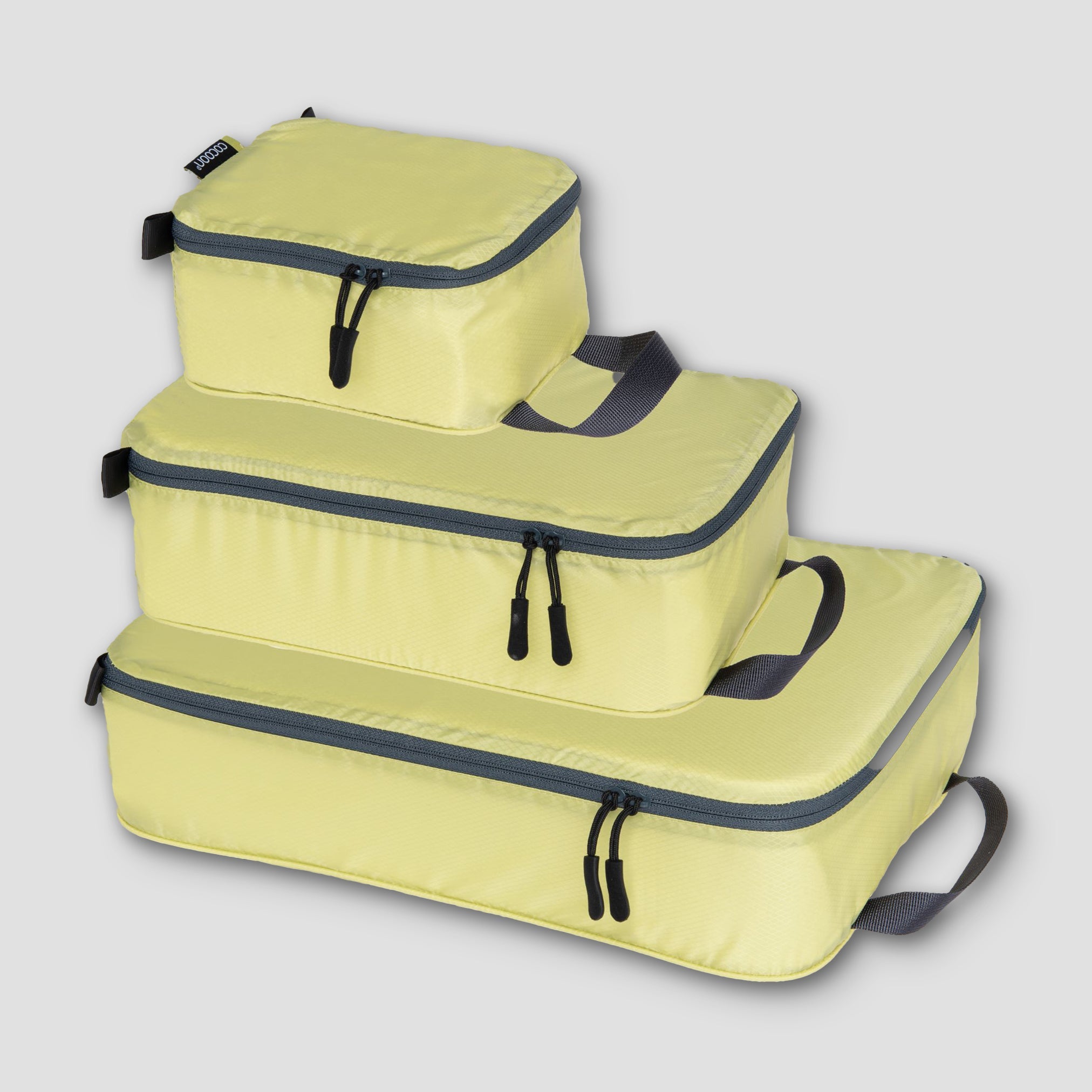 Set of COCOON Discrete Light Packing Cubes for travel organizers, showing multiple lightweight, organized packing cubes in various sizes.